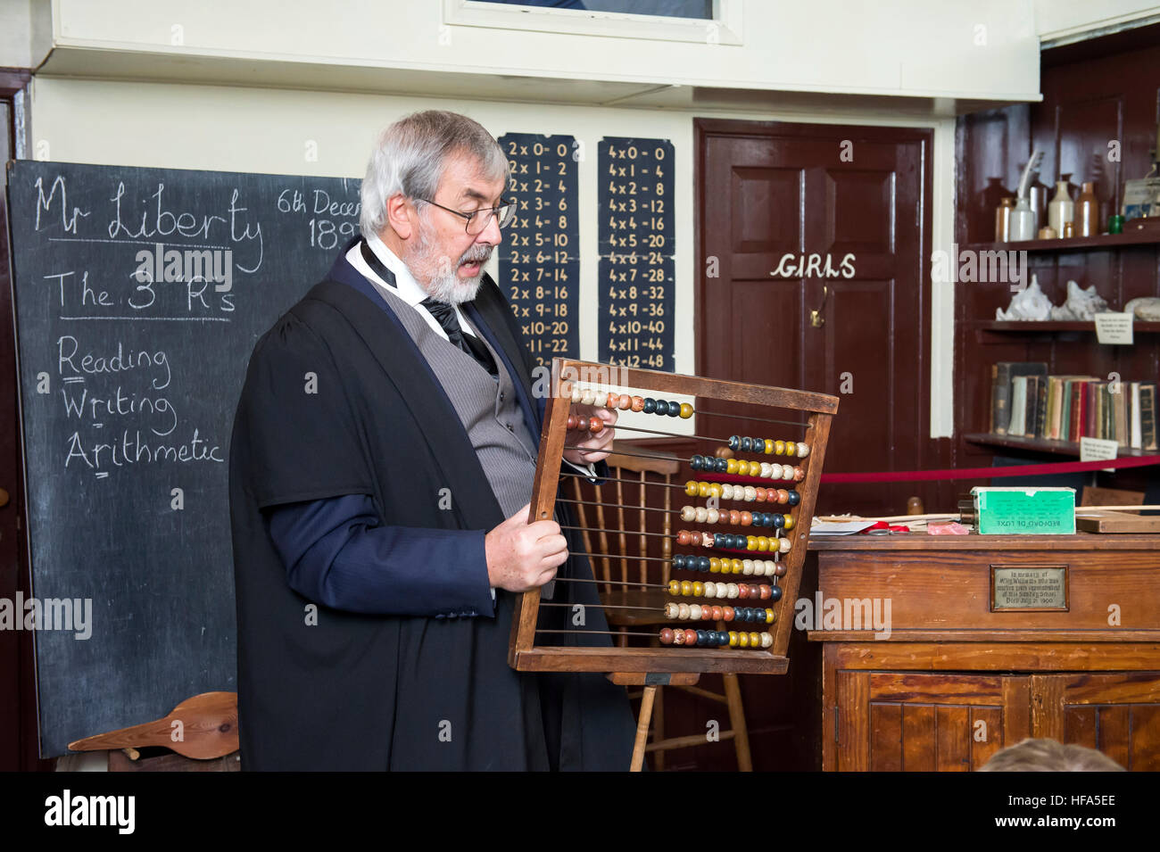 Eine Nachbildung einer viktorianischen Klassenzimmer. Ein Lehrer unterrichtet Mathematik mit einem Abakus. Stockfoto