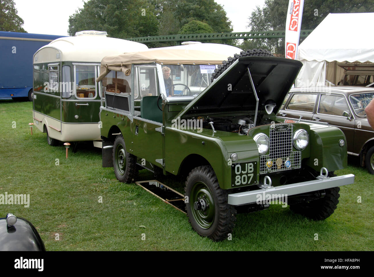 Oldtimer-Besitzer schauen durch Stände von Raritäten und Automobilia bei Beaulieu Teilemarkt-Serie 1 Land Rover mit Wohnwagen Stockfoto