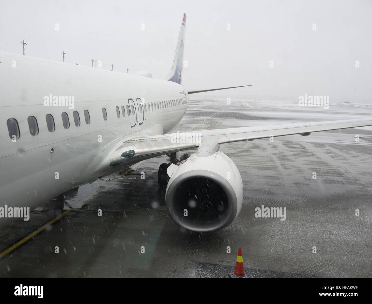 Flughafen Oslo Norwegen im Winter, Flugzeug von der Firma norwegischen bereit zum Einsteigen bei schlechter Sicht und Graupel Stockfoto