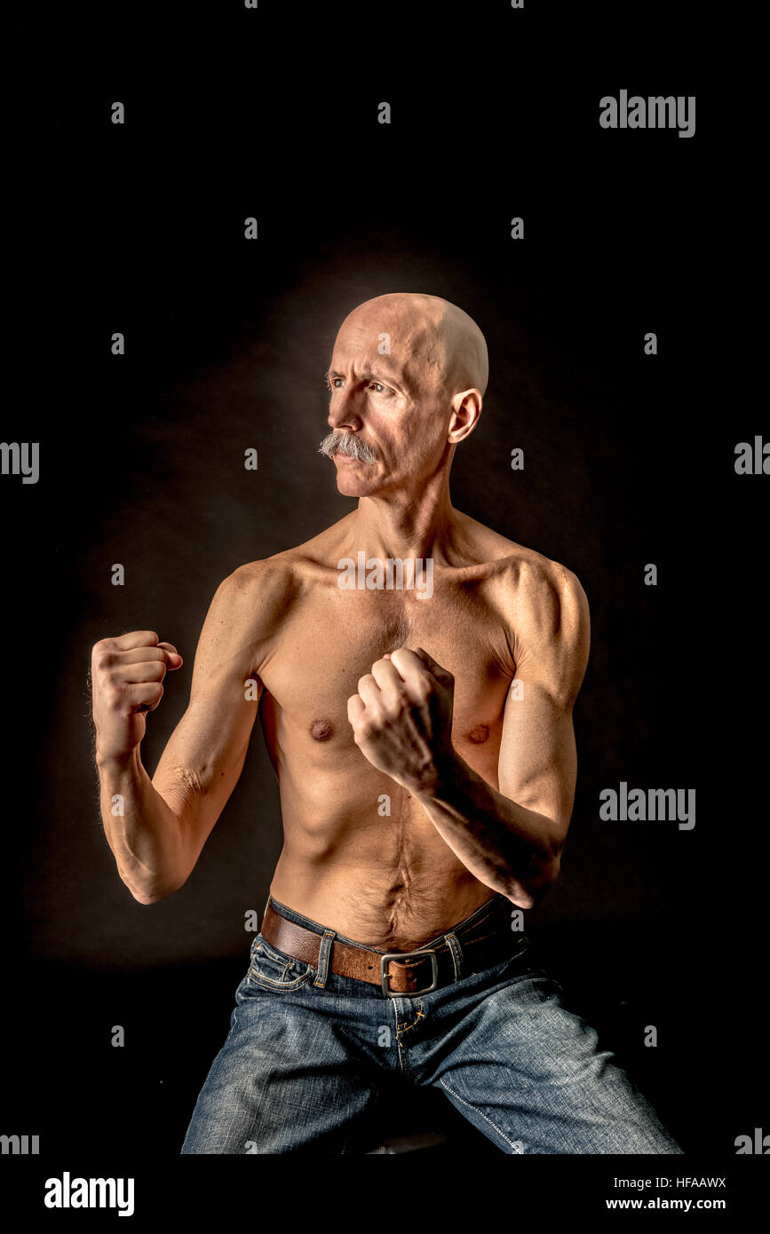 Alter kahler Mann in antiker Kampfstellung Stockfoto