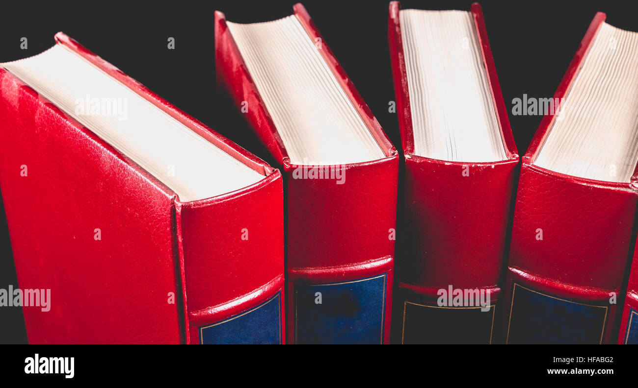 Alte rote Enzyklopädien gebunden Leder auf schwarzem Hintergrund Stockfoto