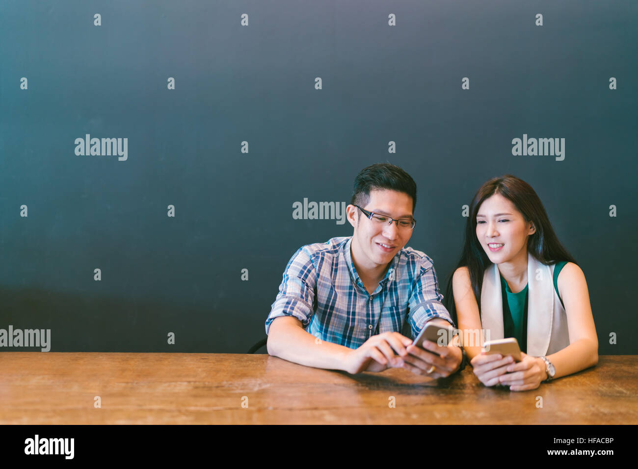 Junge asiatische Paare oder Mitarbeiter mit Smartphone Café, modernen Lifestyle mit Gadget-Technologie oder lässig Geschäftskonzept mit Textfreiraum Stockfoto
