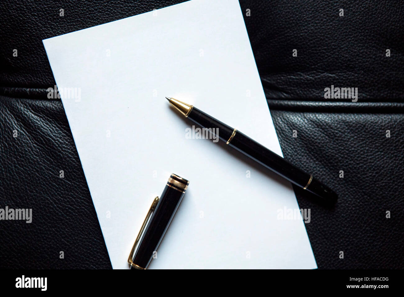 Nahaufnahme von stilvollen Stift und ein Blatt Papier auf schwarzem Leder Stockfoto