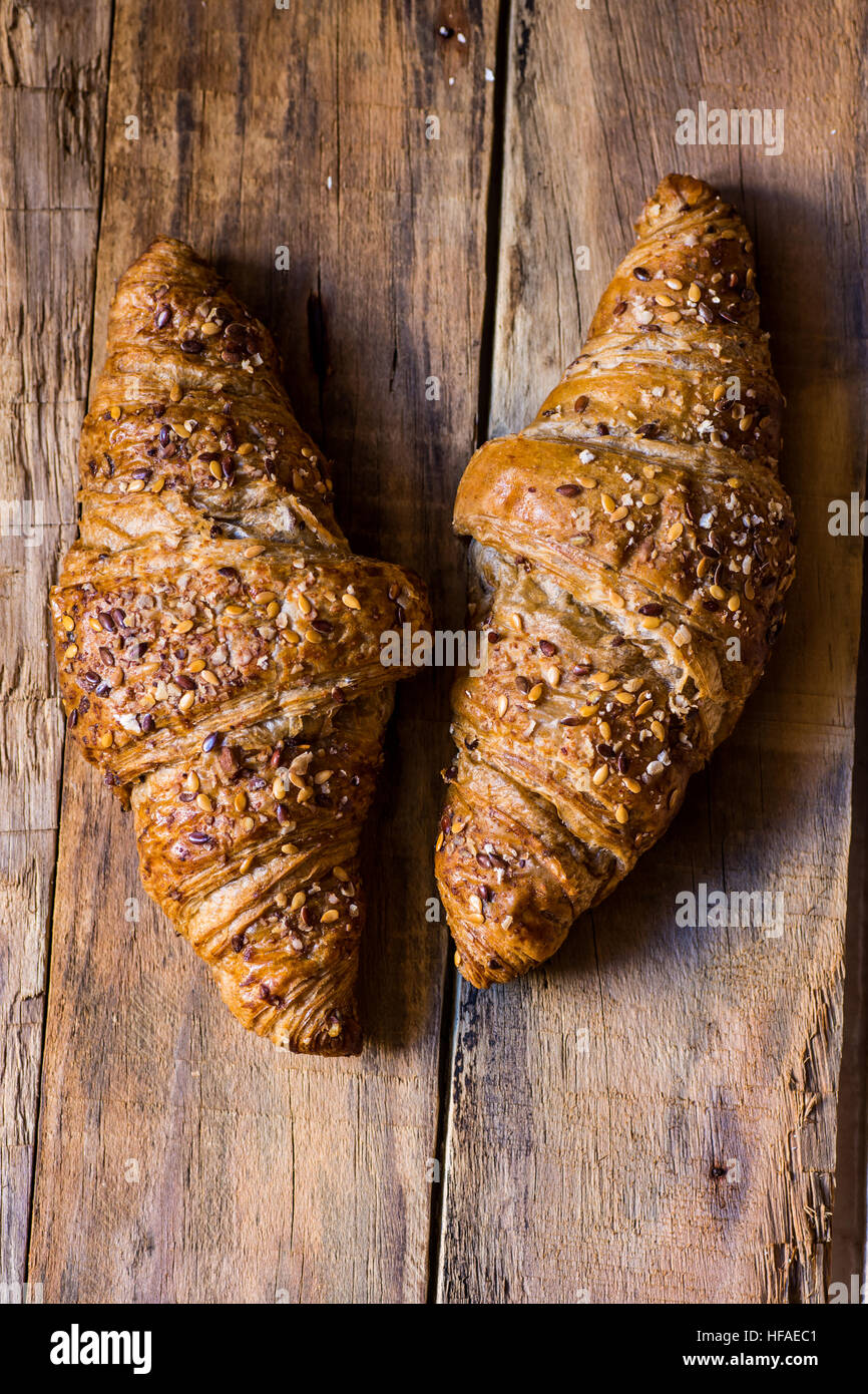 Vollkorn-Croissants auf einem rustikalen distressed Plank Holz Tisch, flache Ansicht von oben, Nahaufnahme, Vintage, gemütliche Atmosphäre Stockfoto