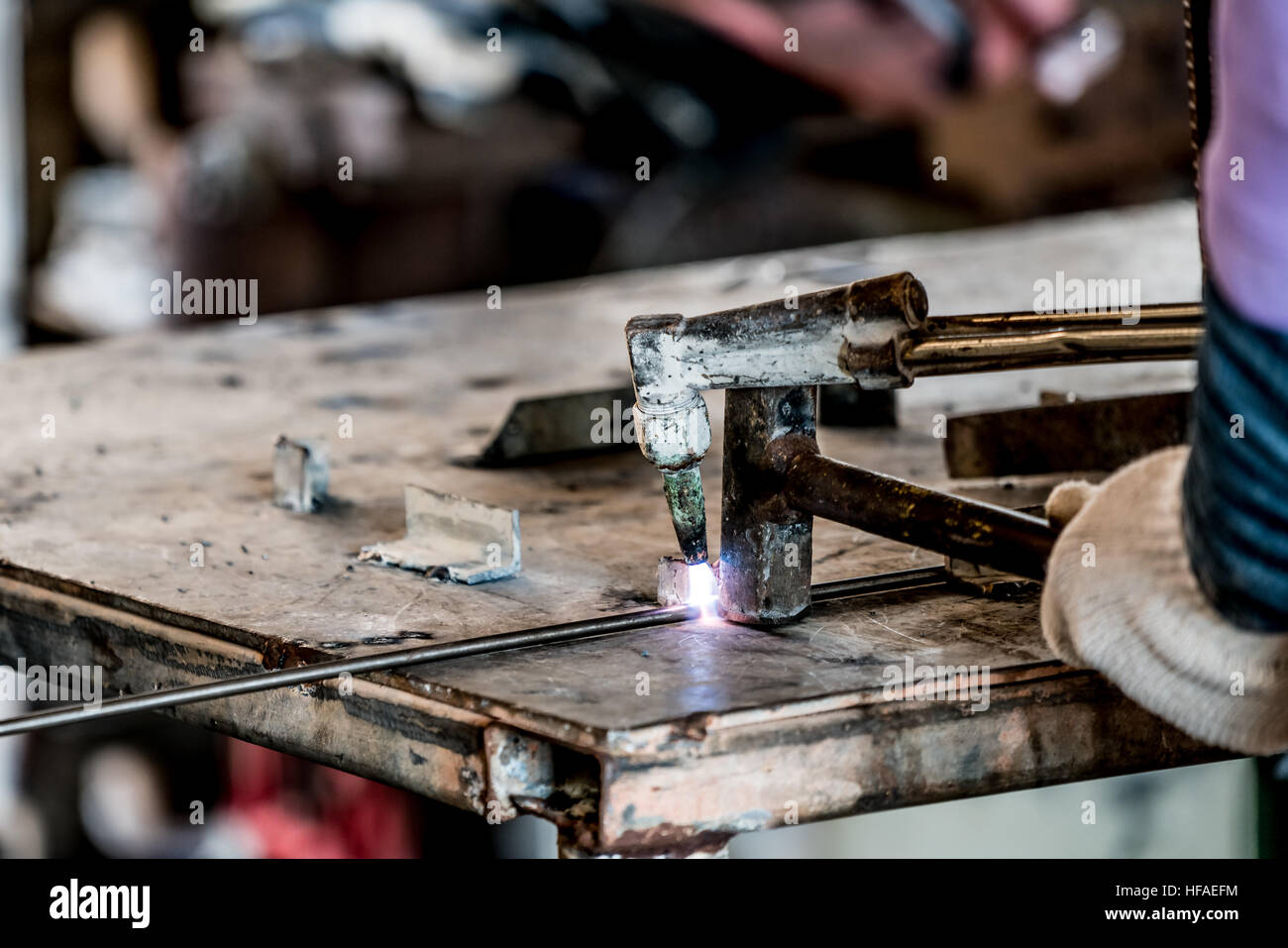 HDR-Bild eines Technikers mit Schweißer in der Werkshalle Stockfoto