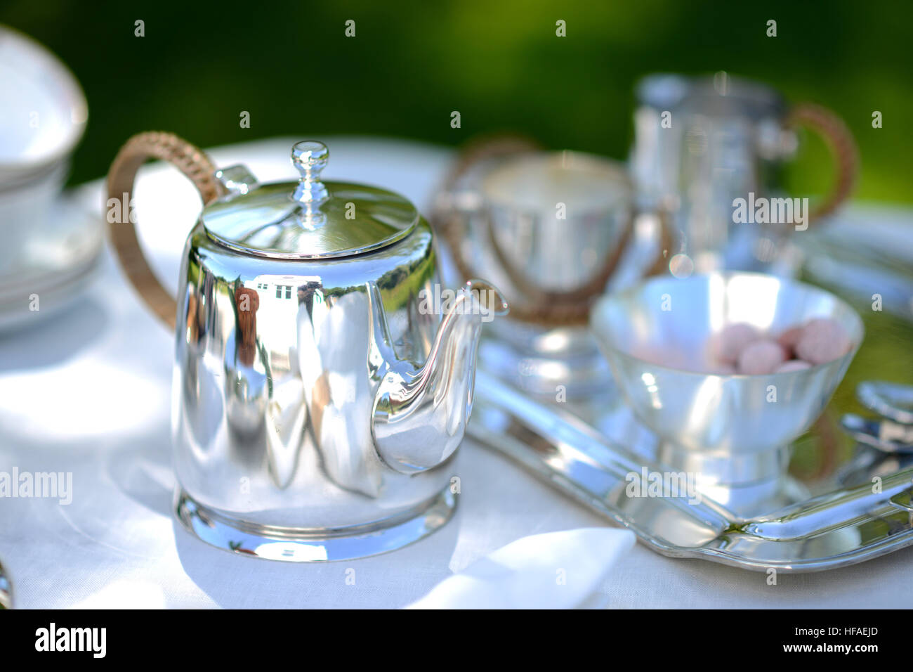 Tisch für einen englischen High Tea oder Tee am Nachmittag, außerhalb mit silberne Teekanne und Leinen Tischdecke Stockfoto