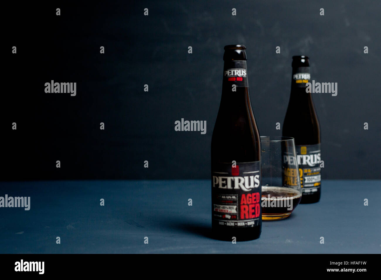 Petrus im Alter von roten & Alter blass Flaschen mit Bier im Glas vor einem grauen Hintergrund Stockfoto