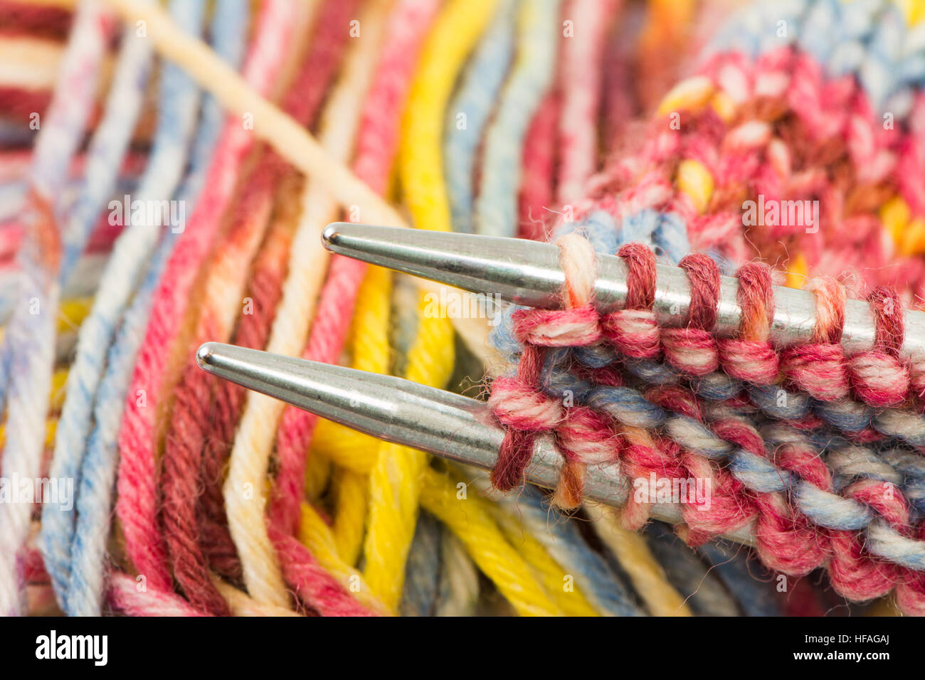 Nahaufnahme von Stricknadeln mit bunten Wolle Stockfoto
