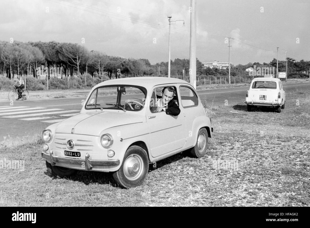 Ein Mann posiert in einem Fiat 500-Auto in Italien in den 1960er Jahren. Stockfoto