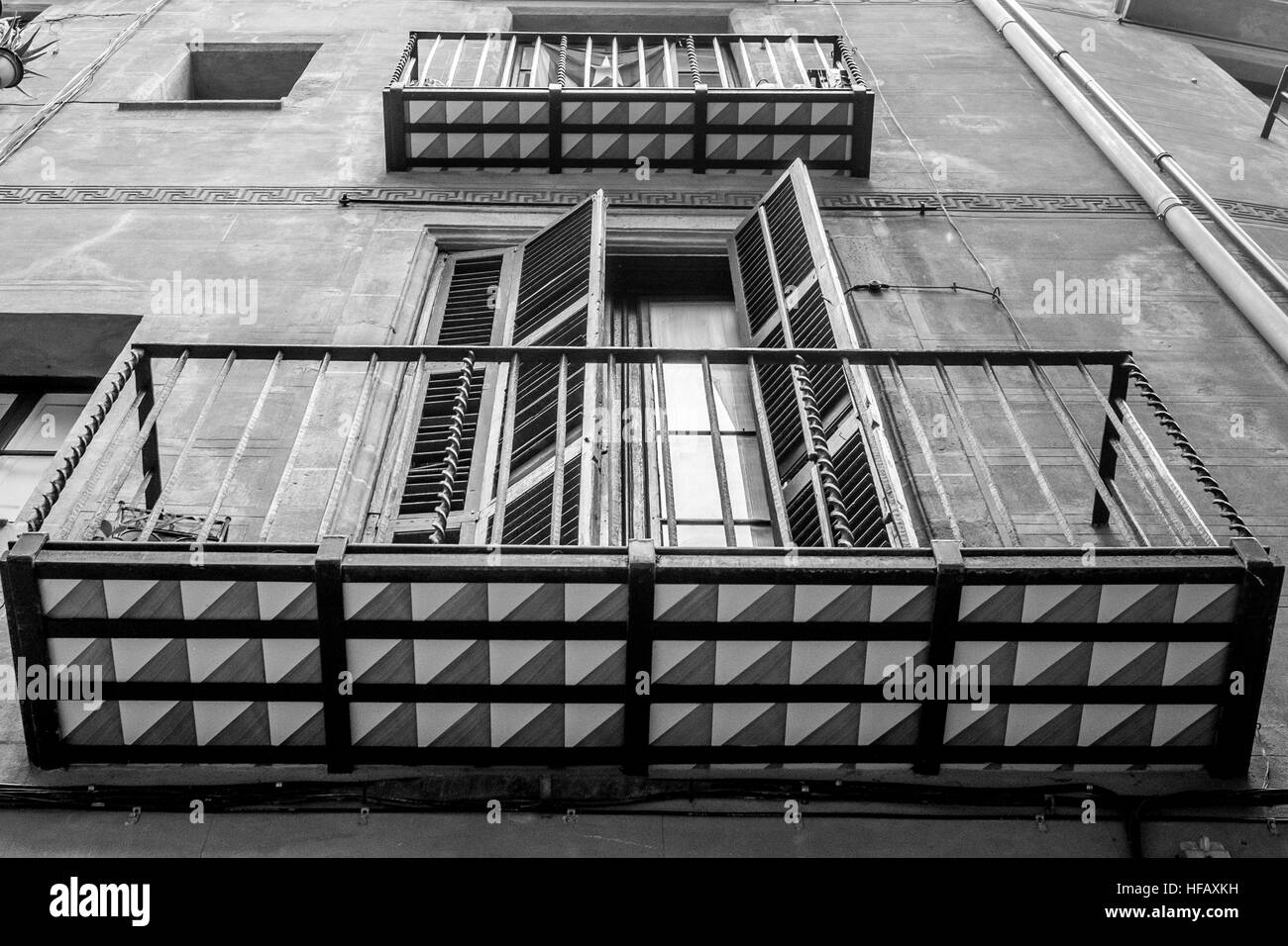 Ein Balkon mit einer offenen Fensterläden Holztür bläst der Wind in Barcelona Stockfoto