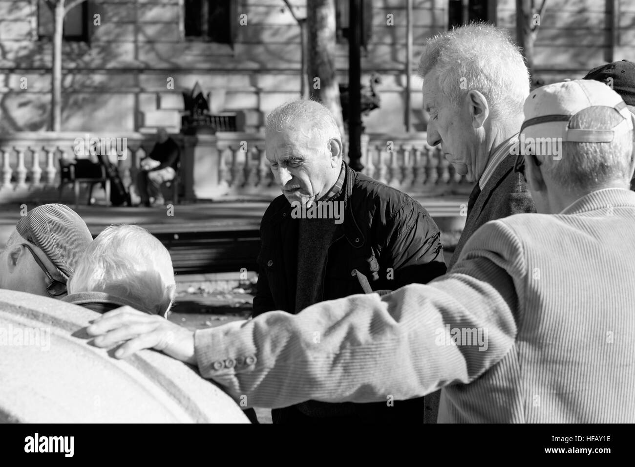 Ältere Männer in einem Park in Barcelona ansehen, wie ihre Freunde Karten zu spielen. Stockfoto