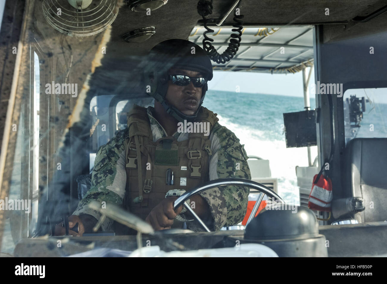 140225-N-LE393-262 Dschibuti (25. Februar 2014) US Navy Lokomotiv 2. Klasse Lonnie Waters, ein Steuermann mit Küsten Riverine Squadron 1, treibt ein 34 Fuß Patrouillenboot während einer Mission um ein amerikanisches Schiff in den Hafen von Dschibuti am 25. Februar 2014 zu eskortieren. CRS-1 führt Anti-Terrorismus, Schutz und Personal Recovery Missionen im Camp Lemonier, Dschibuti Tätigkeitsbereich zu erzwingen. (Foto: U.S. Navy Mass Communication Specialist 1. Klasse Eric Dietrich/freigegeben) CRS-1 Escort Mission 140225-N-LE393-262 Stockfoto