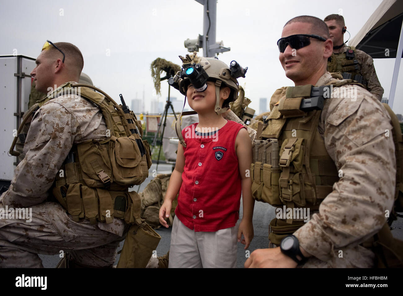 120617-N-CP762-114 Tokio (17. Juni 2012) ein Besucher einen Helm trägt als Staff Sgt Max Veliz, Marine, Flotte Anti-Terrorism Security Team (schnell) Firma Pacific, 3rd Platoon zugewiesen blickt auf in eine offene Schiffstour an Bord den USA 7. Flotte Flaggschiff USS Blue Ridge (LCC-19) in Tokio. Blue Ridge Besuch in Tokio ist ein nach außen Demonstration der US-Engagement für die Verteidigung von Japan, die starke Beziehung zwischen der U.S. Navy und Japan Maritime Self-Defense Force. (Foto: U.S. Navy Mass Communication Specialist 3. Klasse Fidel C. Hart/freigegeben) - offizielle US Navy Bilder - A Besichtigung Stockfoto