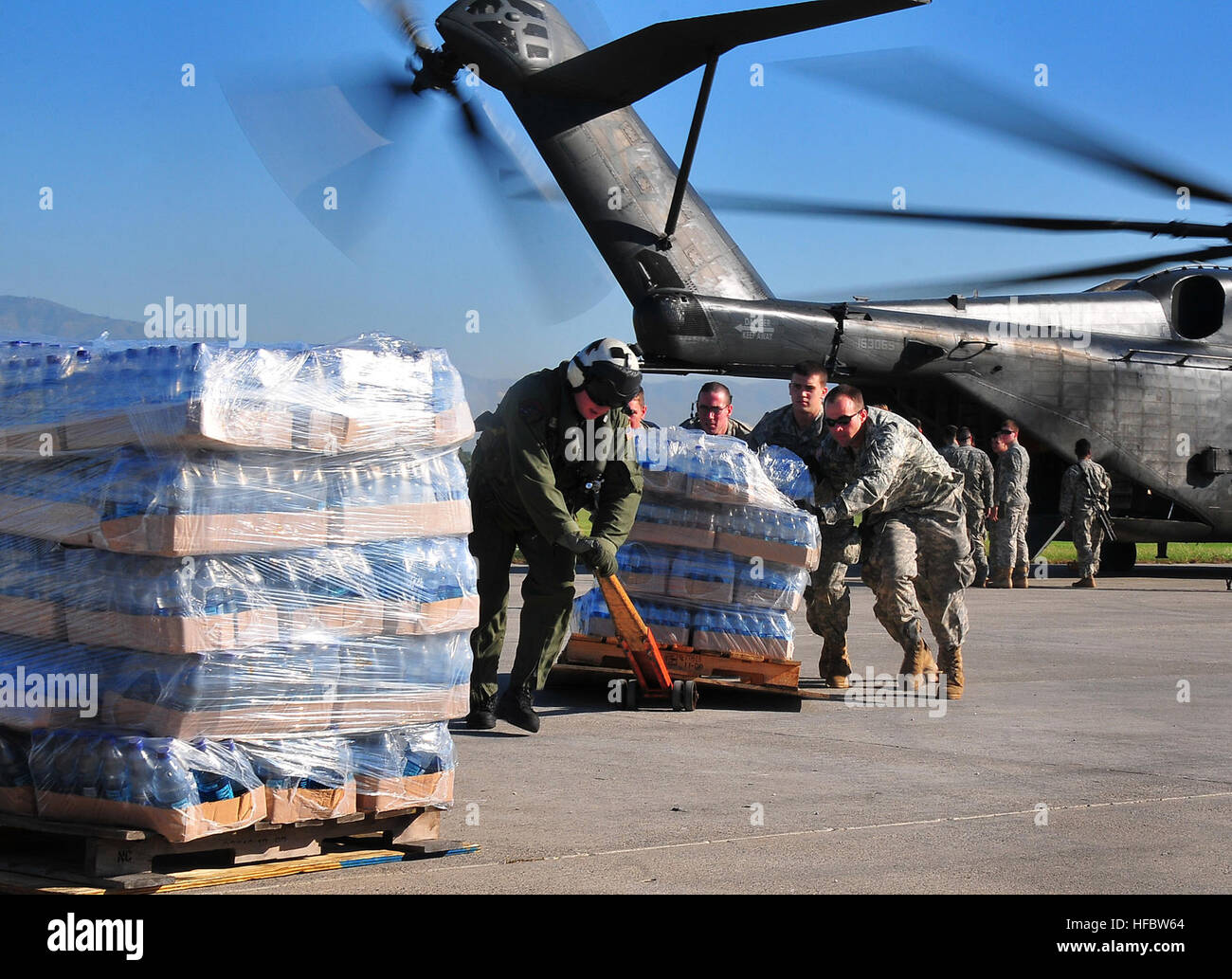 100115-N-4774B-445 PORT-AU-PRINCE (15. Januar 2010) US-Armee Soldaten Hilfe der US-Marine MH-53E Sea Dragon Hubschrauber Besatzung aus dem Flugzeugträger USS Carl Vinson (CVN-70) entladen Lebensmittel und Vorräte auf dem Flughafen in Port-au-Prince, Haiti. Das US-Militär führt humanitäre Hilfe und Katastrophenschutz Hilfsaktionen, nachdem eine Erdbeben der Stärke 7,0 schwere Schäden in der Nähe von Port-au-Prince am 12. Januar 2010 verursacht.  (Foto: U.S. Navy Mass Communication Specialist 2. Klasse Daniel Barker/freigegeben) 2010 Haiti Erdbebenhilfe von der US Army Stockfoto