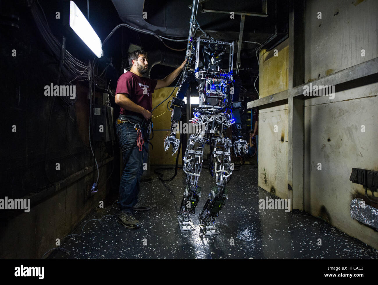 John Seminatore, ein Student an der Virginia Tech, sichert das Office of Naval Research gesponsert an Bord autonomen Brandbekämpfung Roboter (SAFFiR) während der Prüfung an Bord das Naval Research Laboratory Ex-USS Shadwell in Mobile, Alabama Der zweibeinige humanoide Roboter, entwickelt als Prüfstand für autonome Brandbekämpfung und Schadensbegrenzung Operationen, war an eine Stromquelle für Demonstrationen an Bord der Marine Brand Testplattform angebunden. (US Navy Foto von John F. Williams/freigegeben) Herstellung Segler "SAFFiR" - Marine stellt Brandbekämpfung Roboter-Prototyp bei Marine Tech EXPO 141106-N-PO203-269 Stockfoto