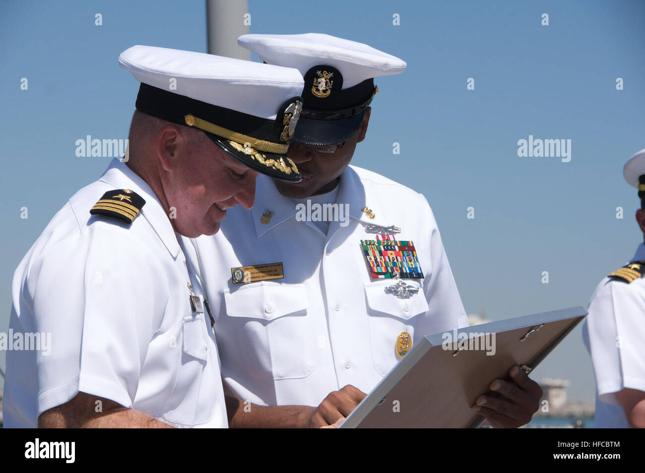 Command Master Chief Jay L. Stuckey präsentiert CMdR Timothy Kott mit dem Schiff Inbetriebnahme Wimpel als er Abschied von der Crew bei einem Befehl Zeremonie auf dem Schiff in Mina Salman Hafen in Manama gebietet. Kott wurde von CMdR Kevin Melody entlastet. (Foto: U.S. Navy Hector Gamez) Melodie entlastet Kott als USS Hopper Commander 262298 Stockfoto