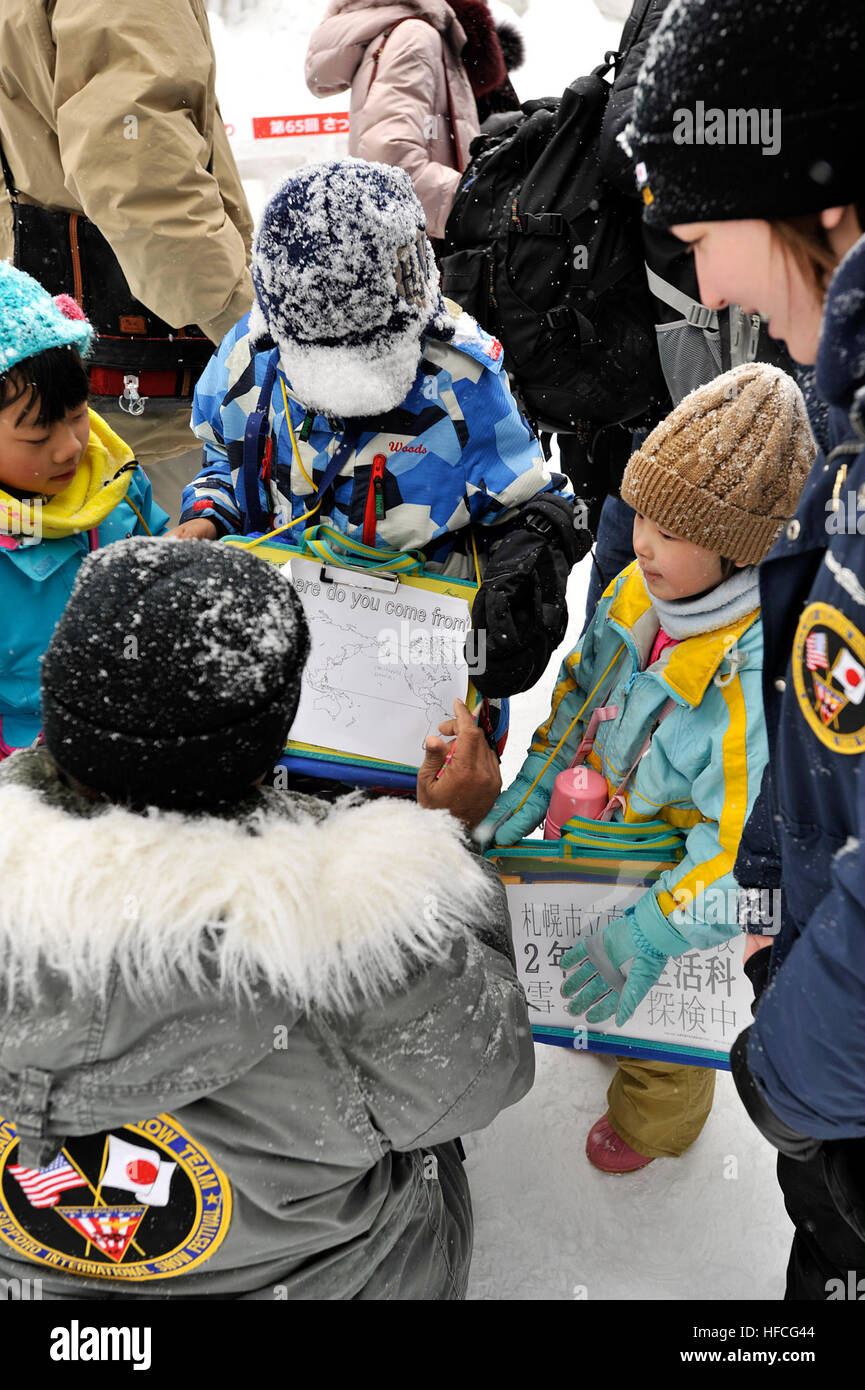 Chief Billy Harger, ein Eingeborener von Pearl City, Hawaii, zeigt einige japanische Schulkinder in seiner Heimatstadt befindet, 5. Februar 2014. Harger ist der Teamleiter des 2014 Navy Misawa Schnee Skulptur-Teams, die in Hokkaido, Japan, Teilnahme an der 65. jährliche Sapporo Snow Festival. Das Team modelliert eine frostige, 3-d-Version von der US Navy Seabee "Kampf gegen Biene" Logo. Dies ist das 31. Jahr, die Naval Air Facility Misawa und seine Mieter Befehle eine Delegation der Segler nach Sapporo, eine Skulptur zu schaffen, und dienen als US-Marine Wohlwollen-Botschafter geschickt haben. Das Festival zieht etwa 2 milli Stockfoto