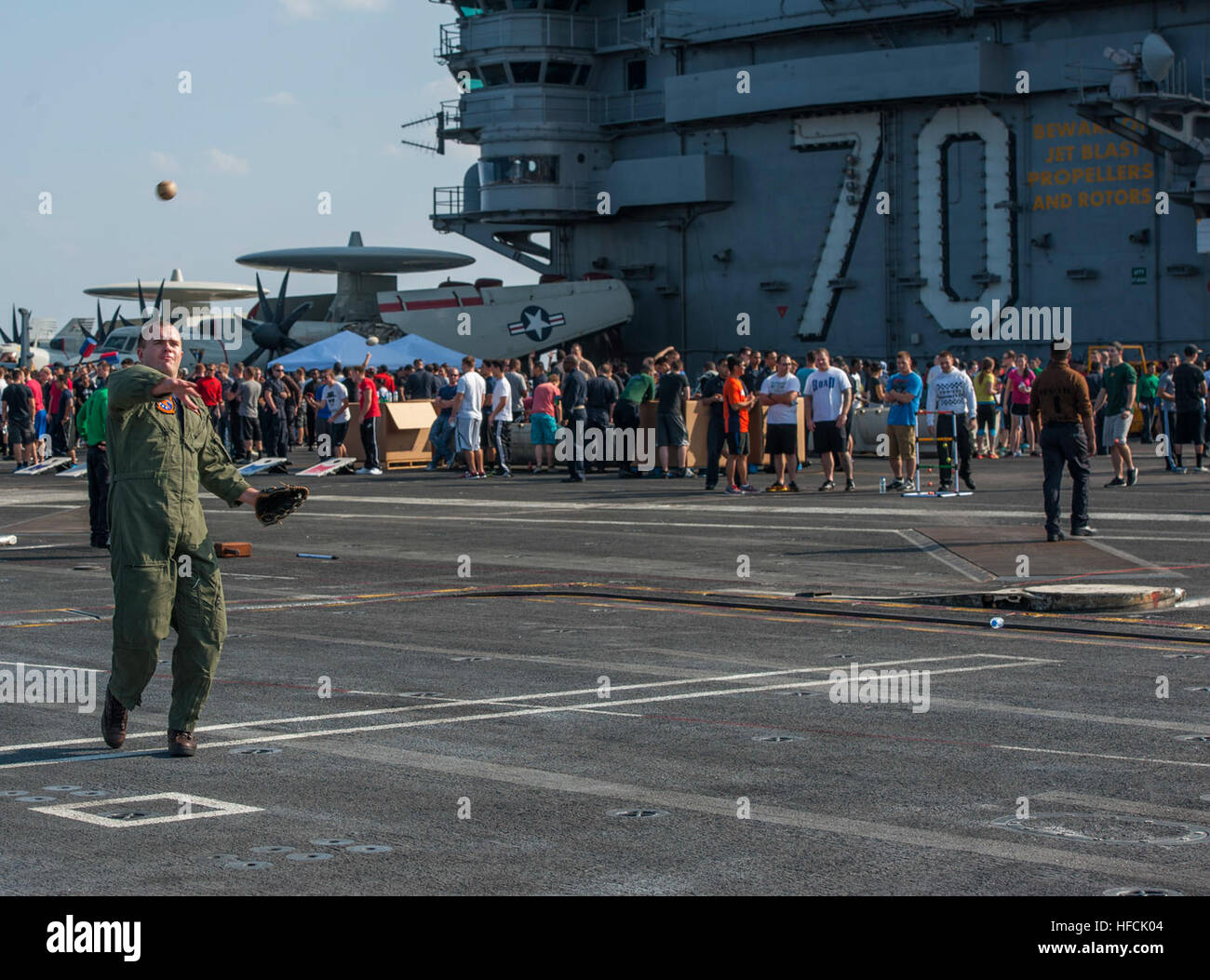 Lt. j.g. Jacob Hawley, zugeordnet zu den Sunliners des Strike Fighter Squadron (VFA) 81, wirft einen Baseball bei einem Stahl Strand-Picknick auf dem Flugdeck der Flugzeugträger der Nimitz-Klasse USS Carl Vinson (CVN-70).  Carl Vinson ist in den USA 5. Flotte Einsatzgebiet unterstützen Betrieb innewohnende zu beheben, Streik Operationen im Irak und in Syrien, wie verwiesen, maritime Sicherheit und Theater Sicherheitsbemühungen Zusammenarbeit in der Region bereitgestellt. (Foto: U.S. Navy Mass Communication Specialist 2. Klasse John Philip Wagner Jr./freigegeben) Betrieb innewohnende Entschlossenheit 141102-N-TP834-266 Stockfoto