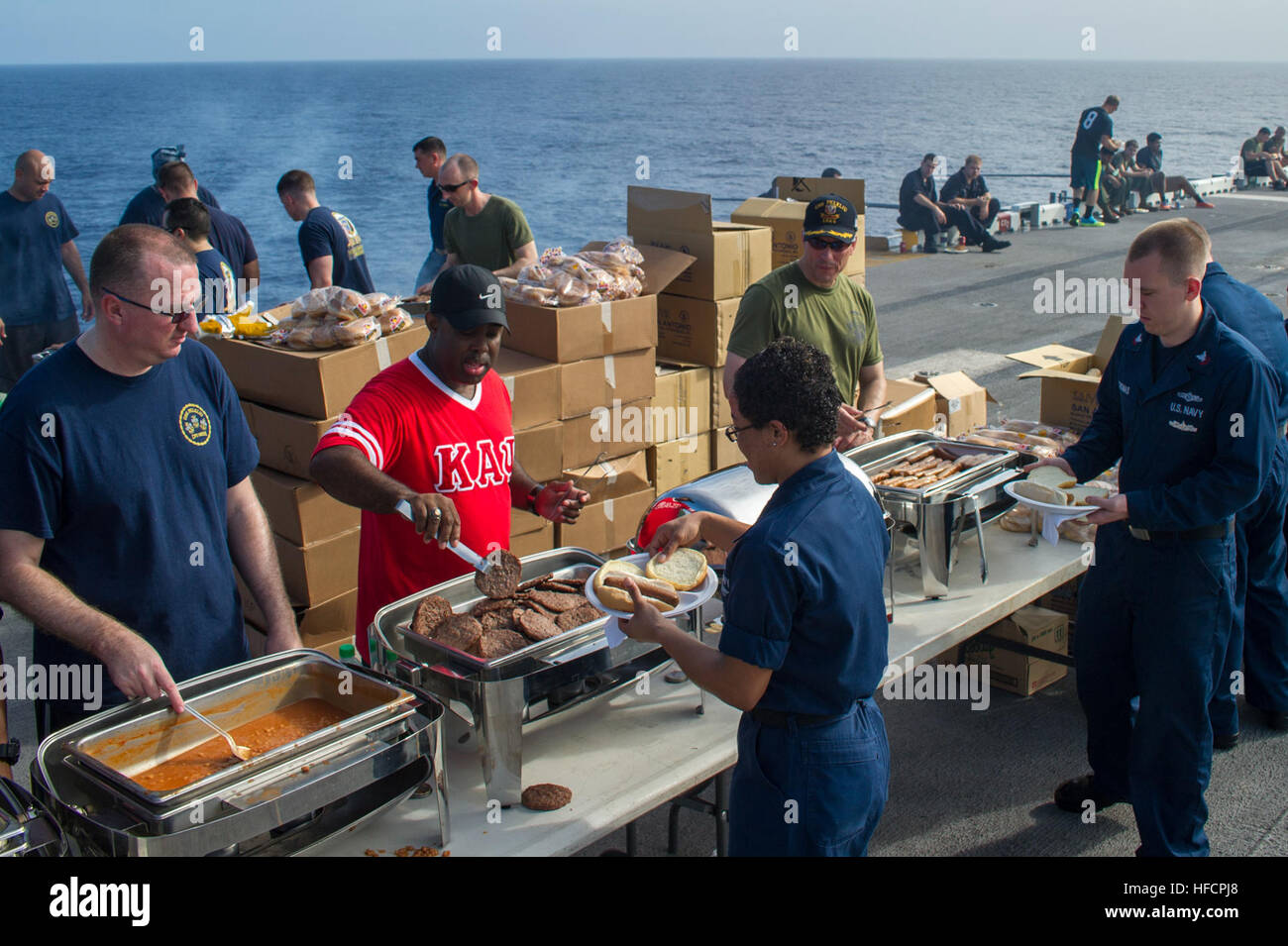 Captain Paul Spedero, rechts, Kommandierender Offizier der amphibischen Angriff Schiff USS Peleliu (LHA-5), Command Master Chief Tyron Flynn, Center und Cryptologic Cheftechniker (Sammlung) Byron Brooks, dienen Matrosen bei einem Stahl Strand Picknick an Bord Peleliu. Peleliu auf seine endgültige westlichen Pazifischen Bereitstellung in den USA wird 7. Flotte Aufgabengebiet Unterstützung von Sicherheit und Stabilität in der Indo-Asien-Pazifik-Region vor der Stilllegung Anfang nächsten Jahres. (Foto: U.S. Navy Mass Communication Specialist 3. Klasse Ryan J. Batchelder/freigegeben) Peleliu hält Stahl Strand Picknick 141121-N-EH218-124 Stockfoto