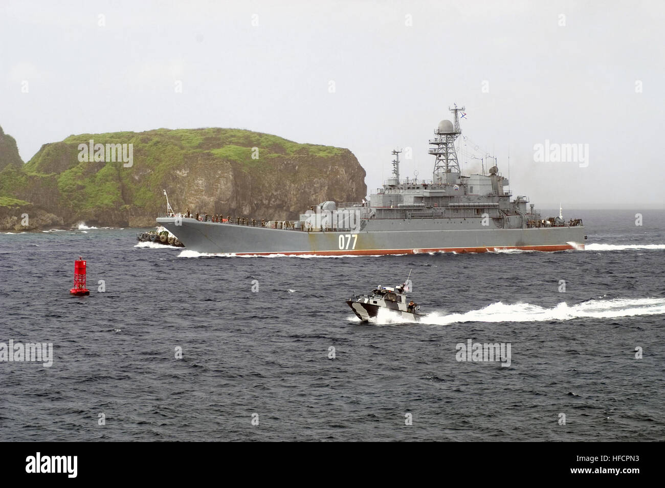 Die russischen Federated Marine (RFN) Tank Landungsschiff BDK 11 (RFN 077) navigiert durch Apra Hafen, Guam (GU), wie ein uns Navy (USN) Harbor Patrol Boat (HPB) Bereich sichert.  Der BDK-11 (RFN 077) nahm in Passing Übung (PASSEX) 2006, vor der Küste von Guam. PERESVET(1) Stockfoto