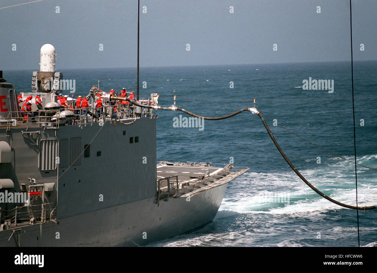 Crew Mitglieder Haul auf einer Linie an Bord der Lenkflugkörper Fregatte USS RENTZ (FFG-46) als eine Betankung Schlauch wird gegenüber dem Flugzeugträger USS RANGER (CV-61) gebracht, während ein im Gange Nachschub. Rentz und Ranger Unrep2 Stockfoto