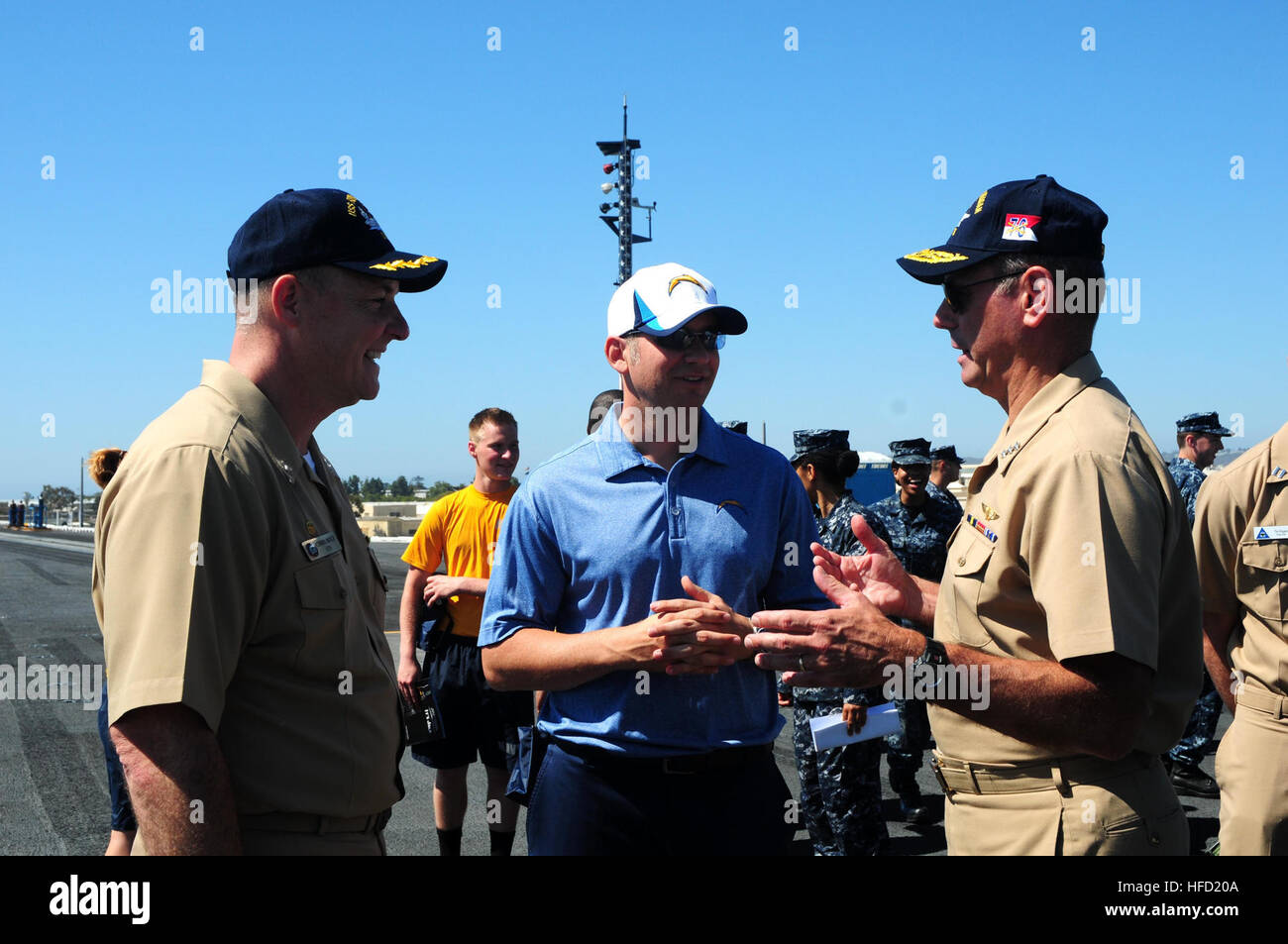 Vice Admiral David H. Buss, Commander Naval Air Forces und Captain Christopher Bolt, Kommandant des Flugzeugträgers USS Ronald Reagan (CVN-76), sprechen Sie mit Alex Spanos, Inhaber der San Diego Chargers, während eine Moral, die Förderung der Veranstaltung mit der San Diego Chargers an Bord des Schiffes. Ronald Reagan ist derzeit vertäut und Zuhause im Naval Base Coronado portiert. (Foto: U.S. Navy Chief Masse Kommunikation Spezialist Terry Feeney/freigegeben) San Diego Chargers besuchen USS Ronald Reagan (CVN-76) 130828-N-QM098-023 Stockfoto