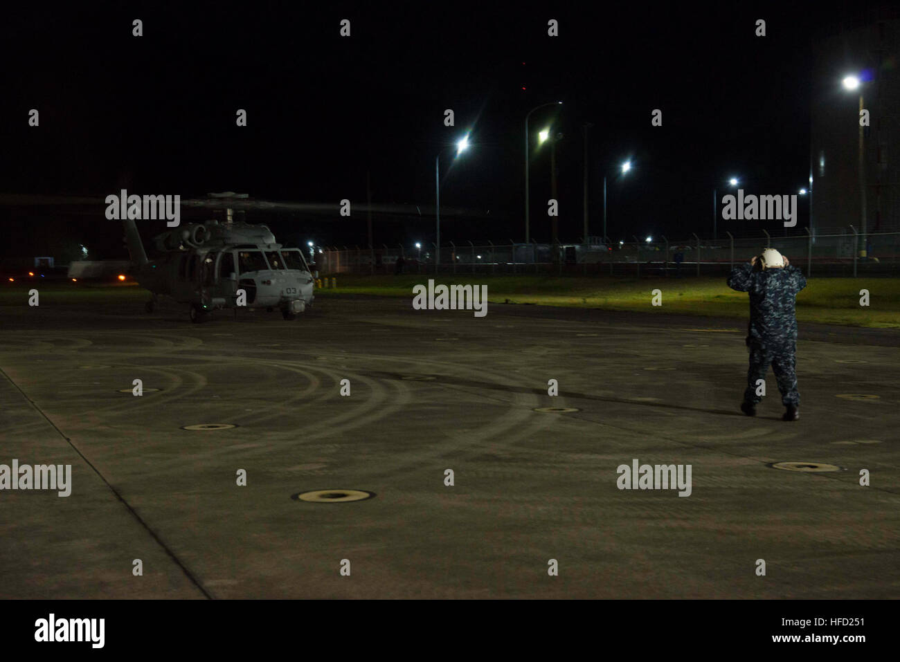 SASEBO, Japan (18. April 2016) Commander, U.S. Flotte Aktivitäten Sasebo Port Operations Officer Chief Warrant Büro Timothy Greene leitet einen Hubschrauber Meer bekämpfen Squadron (HSC) 25 MH-60 Seahawk-Hubschrauber auf dem Rollfeld Aufgewendete 18. April 2016. Der Hubschrauber aufgetankt und Personal gerne bei MV-22 Osprey Operationen aus dem Gefäß zur Unterstützung von Kumamoto Erdbeben Katastrophenhilfe für Japan Maritime Self-Defense Force Hubschrauber Zerstörer JS Hyuga (DDH 181) gebunden in Angriff genommen. Auf Antrag der japanischen Regierung ist US-Truppen in Japan Luftbrücke japanische Selbstverteidigung F unterstützen Stockfoto