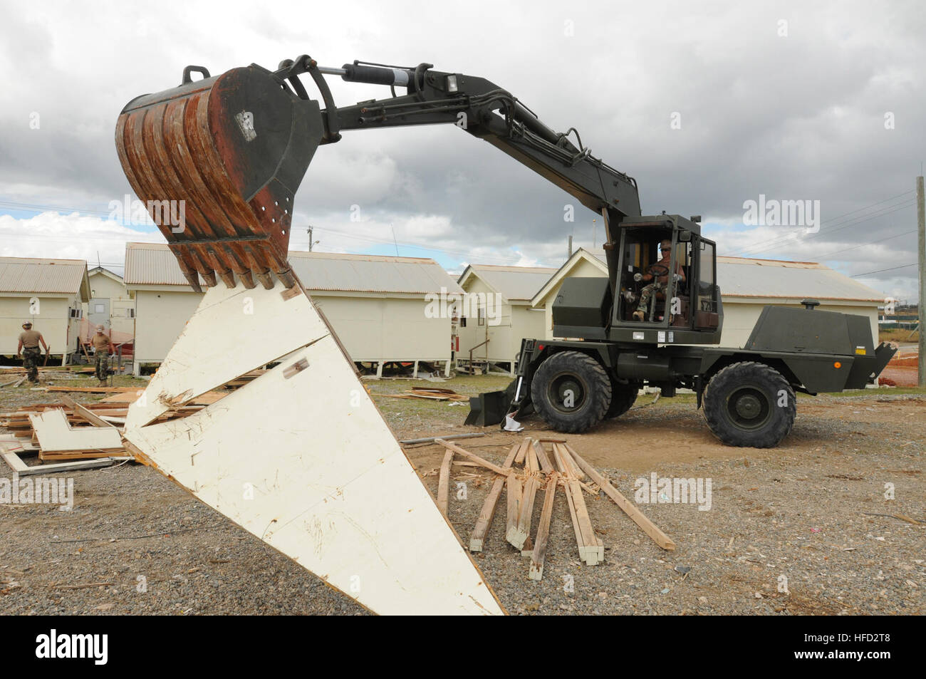 GUANTANAMO BAY auf Kuba – Equipment Operator 2. Klasse James Owen nutzt einen Mobilbagger zum Abbau von Holz aus einer abgerissenen Hütte bei Camp America, 14. Februar.  Die Hütte war für die Joint Task Force Guantanamo als Büro genutzt. Owen ist Naval Mobile Bau-Bataillon 28, Shreveport, Louisiana, beigemessen, was in Guantanamo Bay zur Unterstützung allgemeiner Maschinenbau, Konstruktion und Projektmanagement für Naval Station Guantanamo Bay bereitgestellt wird.  JTF Guantanamo bietet sichere, humane, rechtliche und transparente Betreuung und Verwahrung der Gefangenen, einschließlich Militärkommission und die verurteilten angeordnet rele Stockfoto