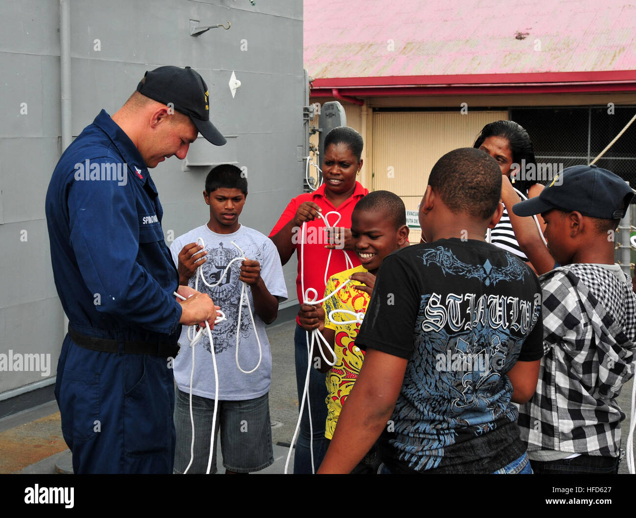 US Marine Bootsmann? s Mate 1. Klasse Dmitry Spiridonov lehrt Knoten binden für Kinder mit der Wiege Center und Rainbow Rescue wie man eine Position in einem Diagramm während eines Gemeindeprojektes Beziehungen an Bord der Lenkflugkörper Fregatte USS Underwood (FFG 36) 8. September 2012, Grundstück in Port Of Spain, Trinidad. Underwood in Mittel- und Südamerika und der Karibik zur Unterstützung der südlichen Meere 2012 bereitgestellt. Südsee ist ein unter der Regie von US Southern Command zur Stärkung der Beziehungen mit regionalen Partnernationen und Einsatzbereitschaft für alle zugewiesenen Einheiten zu verbessern. (US Navy Foto Stockfoto