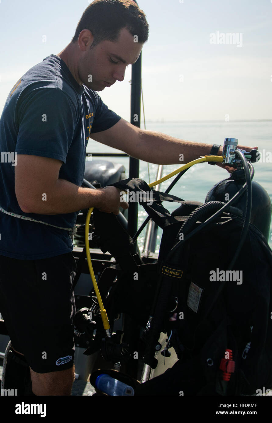 Navy Diver 3. Klasse Tschad Crawford, links, und Navy Diver 2. Klasse Steve Starner, Mobile Tauchen und Salvage Unit (MDSU) 2, 2-2, Firma zugewiesen don ihre Scuba-Rigs in der Vorbereitung für eine Inspektion Tauchgang. MDSU 2, Firma 2-2 ist Commander Task Group 56,1 zugeordnet, Förderung der Grube Gegenmaßnahme, explosive Ordnance Entsorgung, retten, Tauchen und Schutz für die USA zu erzwingen 5. Flotte Aufgabengebiet. (Foto: U.S. Navy Mass Communication Specialist 3. Klasse Jümar T. Balacy/freigegeben) Anti-Terror Force Protection Inspektion Tauchen 130227-N-GG400-008 Stockfoto