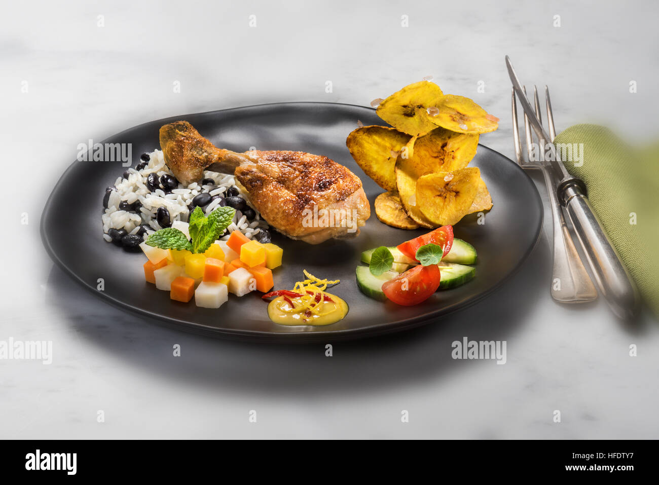 Typische kubanische Speisen, Huhn, Reis mit schwarzen Bohnen, gebratene Bananenchips, Salat und Gemüse. KUBA. Kuba Essen Stil Styling Essen Stockfoto