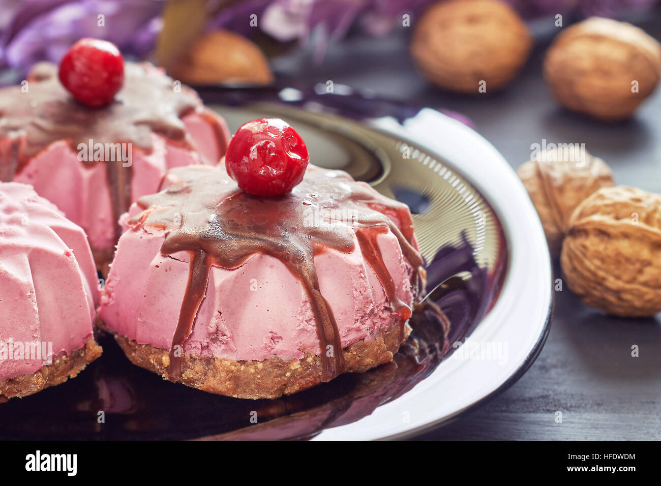 Roh Vegan Dessert mit Sauerkirschen, Datteln und Walnüsse auf schwarzem Teller serviert Stockfoto