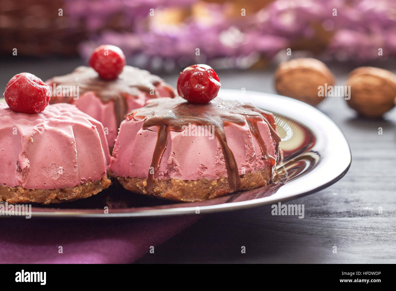 Roh Vegan Dessert mit Sauerkirschen, Datteln und Walnüsse auf schwarzem Teller serviert Stockfoto