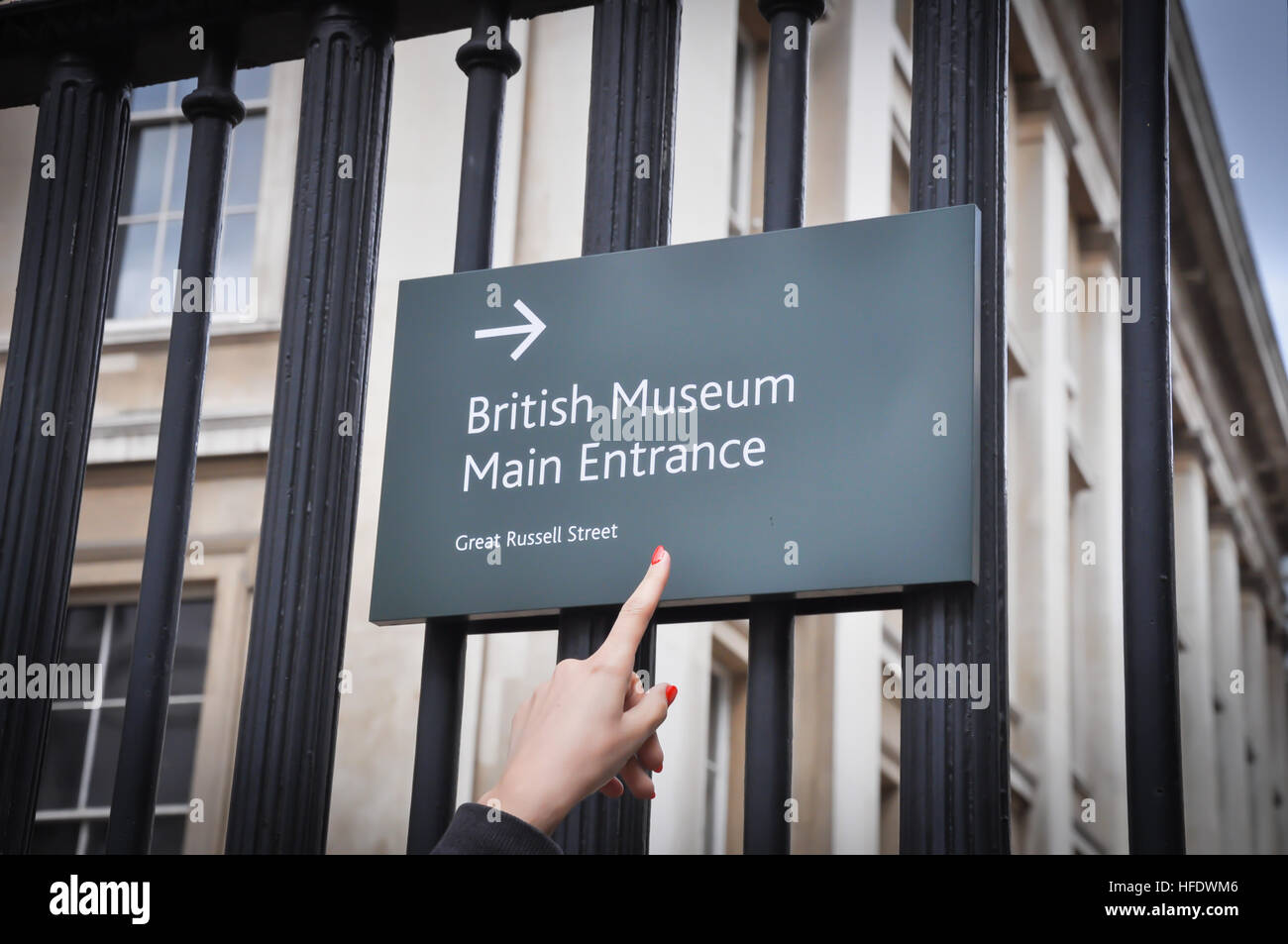 Junge weibliche Touristen zeigen am britischen Museum Haupteingang-Schild Stockfoto