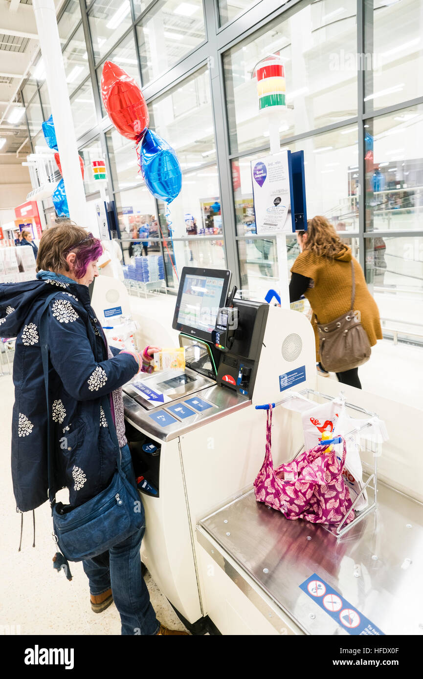 Supermarktkasse: ein Frau-Shopper mit der SB-Kasse in der Tesco-Supermarkt-Superstore, Aberystwyth Wales UK (am Tag Eröffnung des Ladens 24. November 2016) Stockfoto
