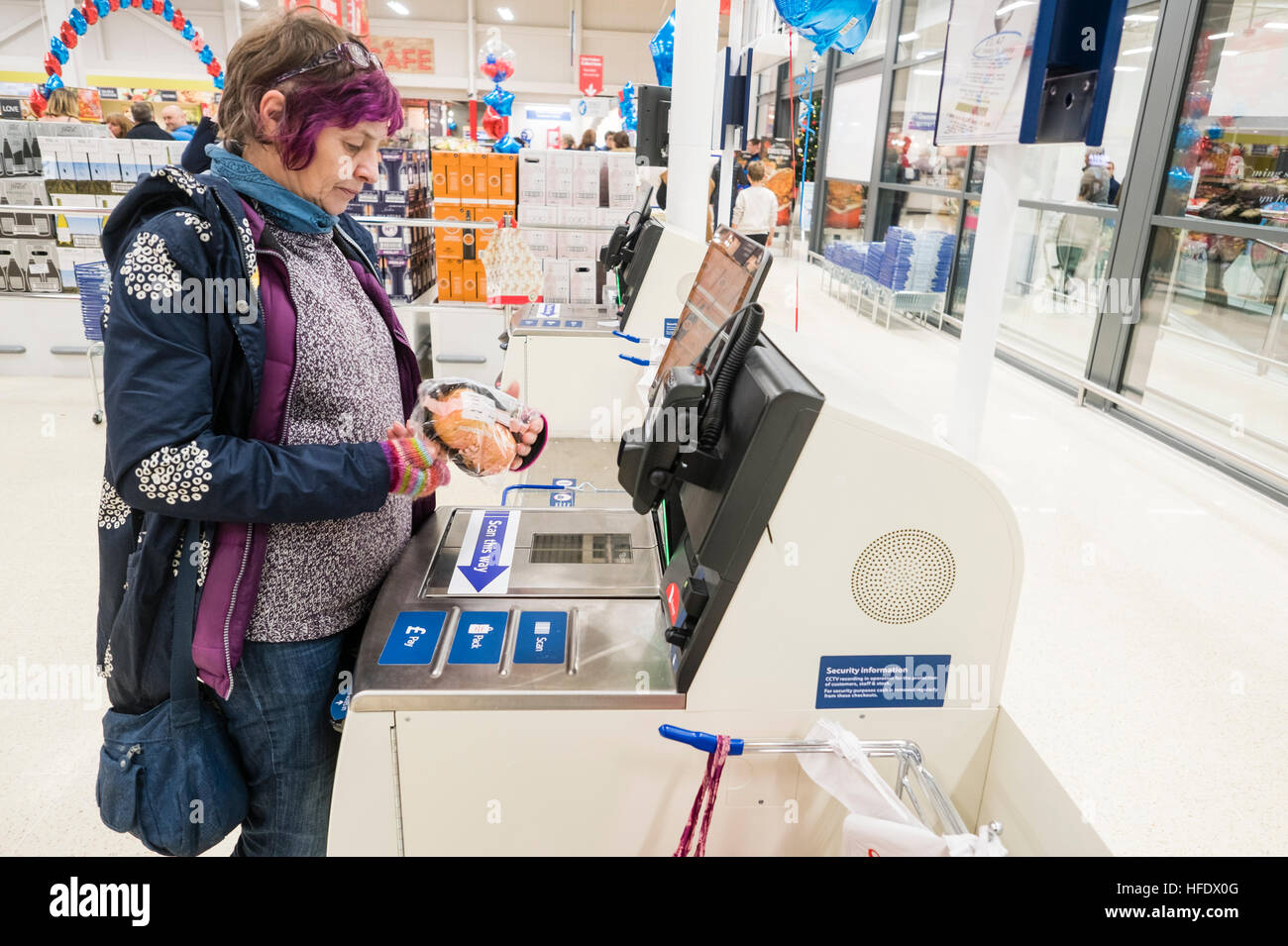 Supermarktkasse: ein Frau-Shopper mit der SB-Kasse in der Tesco-Supermarkt-Superstore, Aberystwyth Wales UK (am Tag Eröffnung des Ladens 24. November 2016) Stockfoto