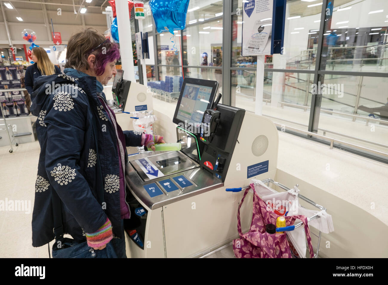 Supermarktkasse: ein Frau-Shopper mit der SB-Kasse in der Tesco-Supermarkt-Superstore, Aberystwyth Wales UK (am Tag Eröffnung des Ladens 24. November 2016) Stockfoto