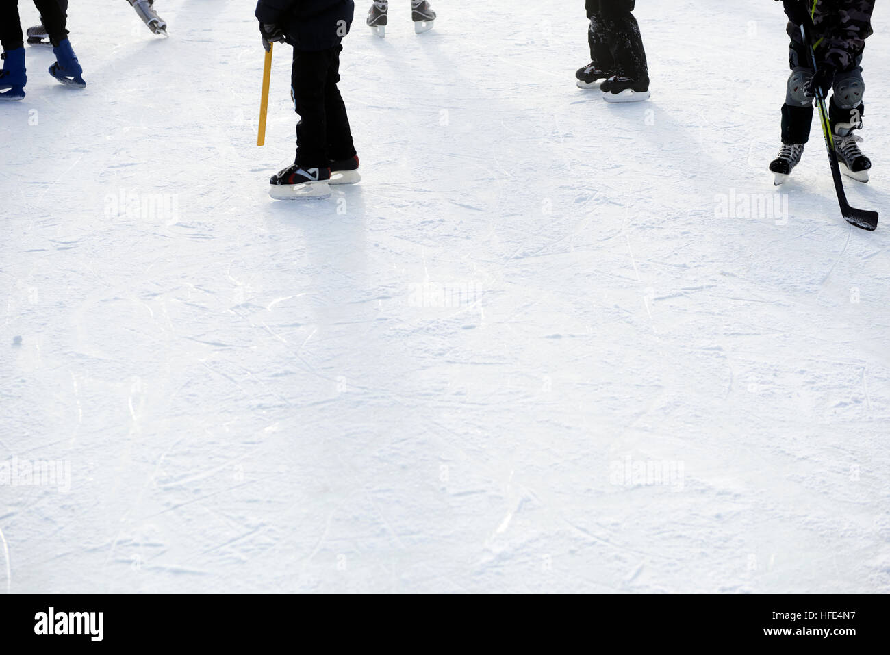 Eine Gruppe von Kindern auf der Eisbahn außerhalb im Winter Eishockey zu spielen. Stockfoto