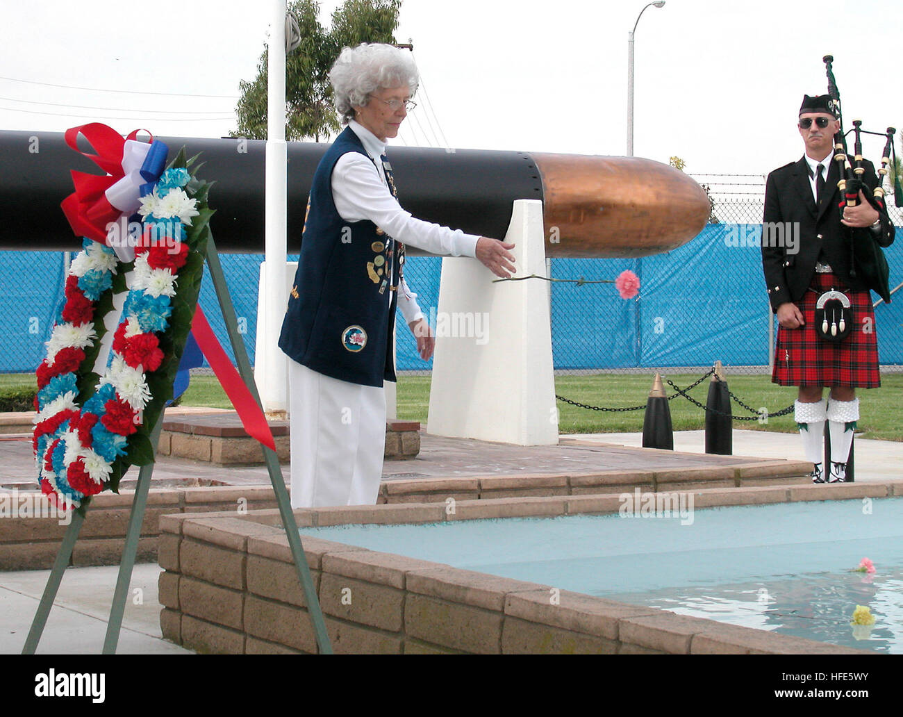 041111-N-1159B-021 Seal Beach, Kalifornien (11. November 2004) Ð die Ehefrau eines zweiten Weltkrieg US-u-Boot-Veteranen, wirft eine Blume in ein Wasserbecken zu Ehren der Erinnerung an eines der 52 u-Boote verloren während des zweiten Weltkriegs im nationalen u-Boot Denkmal-West an Bord Naval Waffen Station Seal Beach, Kalifornien Auf dieser Veterans Day übertragen das u-Boot-Veteranen des zweiten Weltkrieges Eigentum des Denkmals an die US-Marine. Foto: U.S. Navy Journalist 2. Klasse Brian Brannon (freigegeben) wirft uns Marine 041111-N-1159B-021 die Ehefrau eines zweiten Weltkrieg US-u-Boot-Veteranen, eine Blume in einem Reflecti Stockfoto