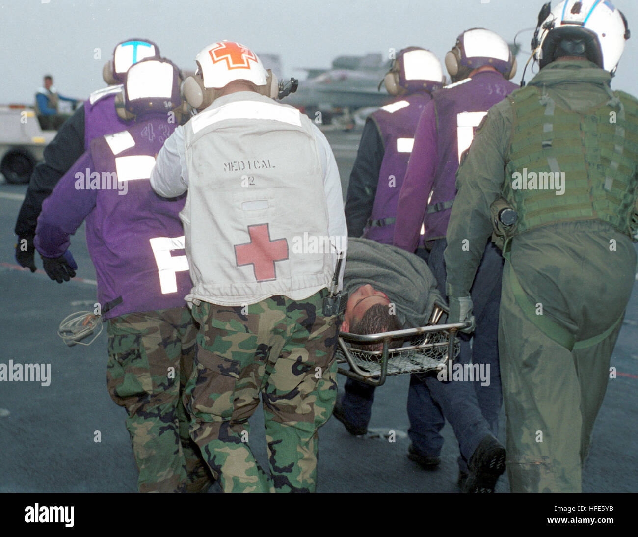 Die Besatzung des Flugdecks schickt einen Airman zu einem medizinischen Gerät an Bord des Flugzeugträgers USS Constellation (CV 64), nachdem er von einem SH-60B Seahawk Helikopter aus der Anti-U-Boot Squadron Two (HS-2) nach einem Vorfall über Bord geborgen wurde. Stockfoto