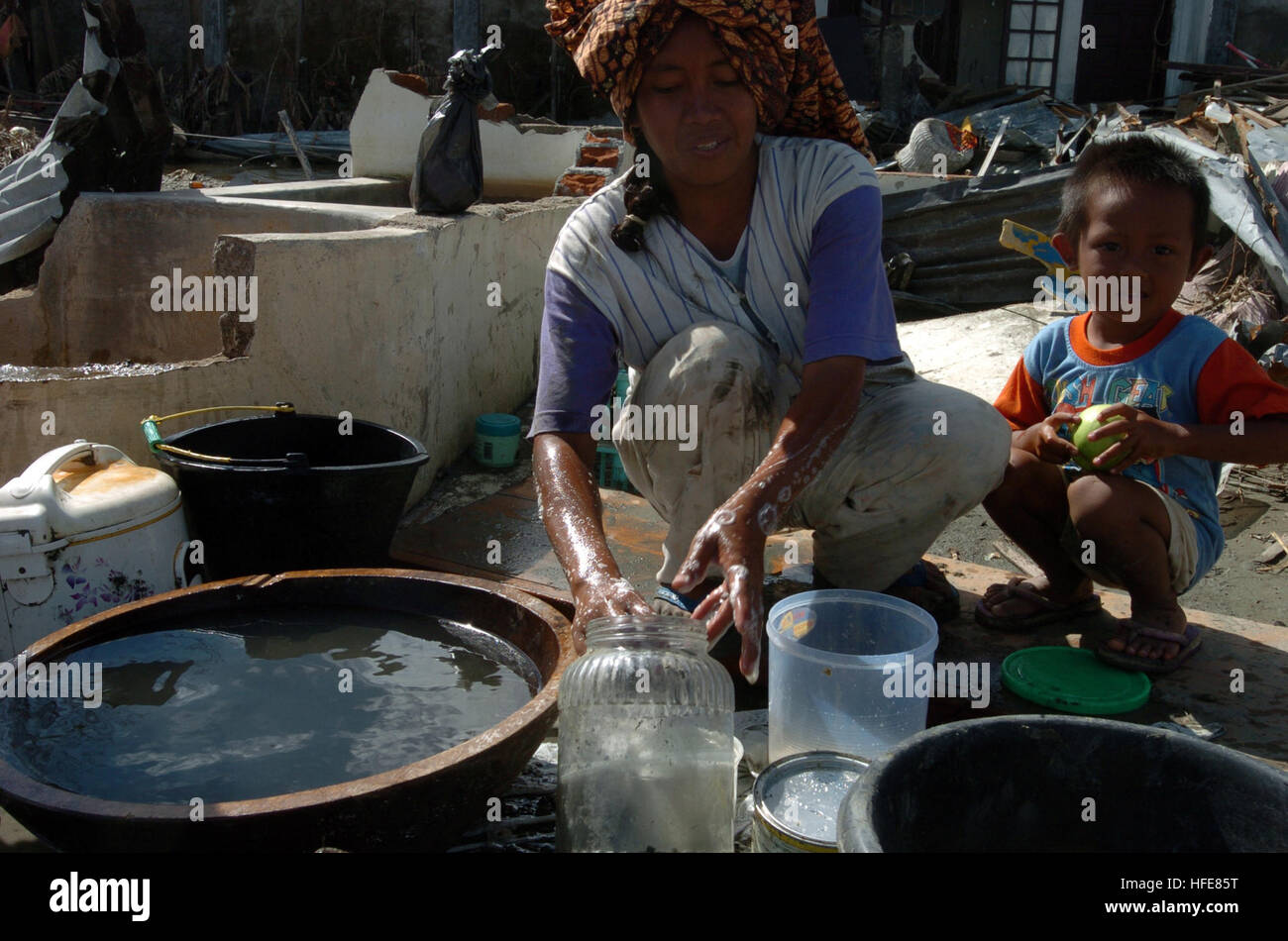 050113-N-7586B-266 Meulaboh, Sumatra, Indonesien (13. Januar 2005) Ð Gerichte eine indonesischen Frau und Kind waschen inmitten der Trümmer in der Stadt Meulaboh auf der Insel Sumatra, Indonesien. Mehr als 18.000 Marines, Matrosen, Flieger, Soldaten und Küste Gardisten mit kombiniert Support Force 536 (CSF-536) arbeiten mit internationalen militärischen und kommerziellen Organisationen zur Unterstützung der betroffenen Bevölkerung von Thailand, Sri Lanka und Indonesien nach eine Erdbeben der Stärke 9,0 verheerende Tsunamis auslösen. Internationalen Anstrengungen zur Minimierung von Leiden und Verluste an Menschenleben infolge der Auswirkungen des Ohres zu mildern Stockfoto