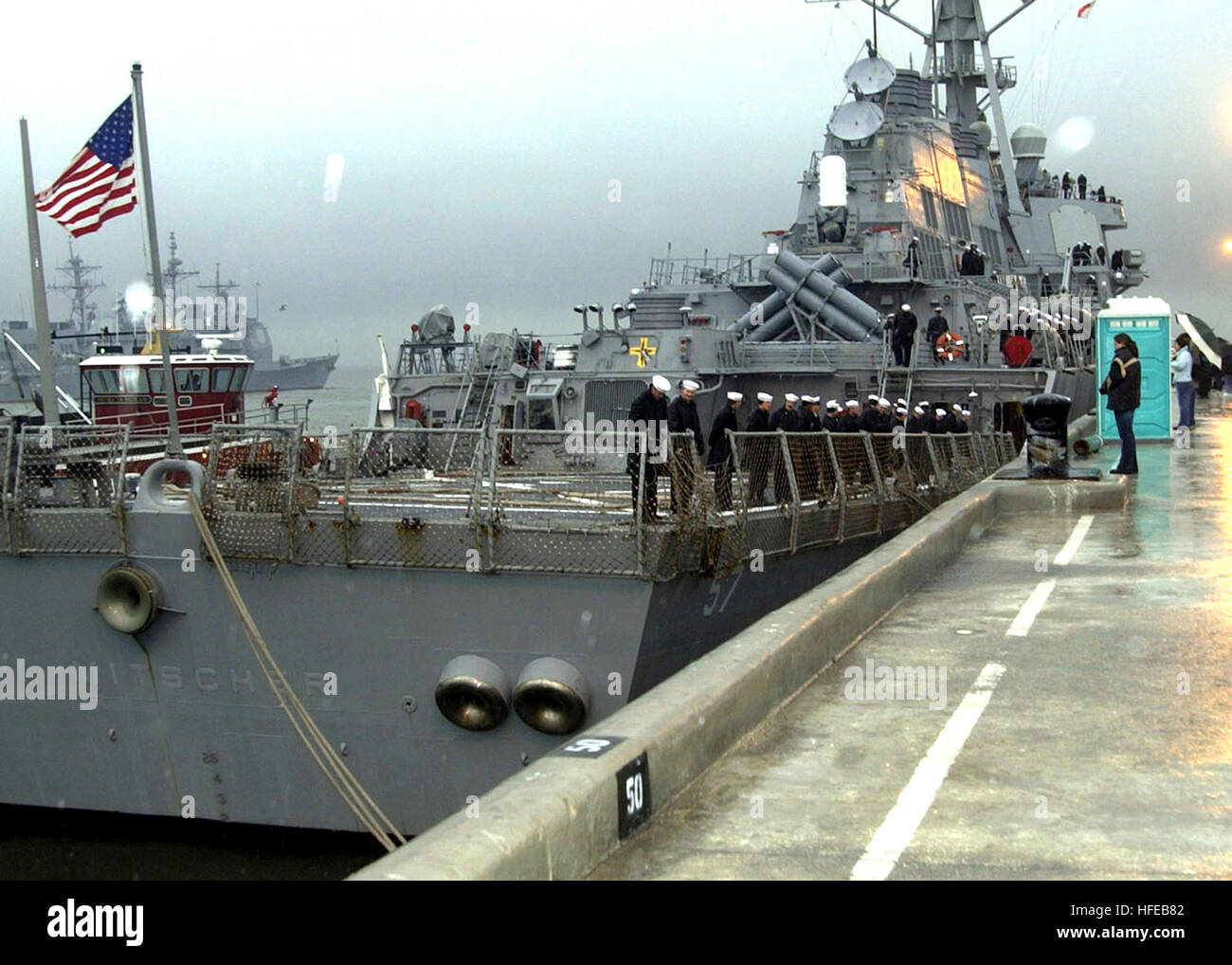 021205-N-9251B-002 Norfolk, Virginia, (5. Dezember 2002)--Matrosen an Bord USS Mitscher (DDG-57) 'man die Schienen' während Angehörige und Freunde schauen auf im Regen.  Die Mitscher fährt für einen regelmäßigen Einsatz mit Harry S. Truman Battle Group Operation Enduring Freedom.   US Navy Foto vom Fotografen Paaren 1. Klasse Marthaellen L. Ball.  (FREIGEGEBEN) U.S. Navy 021205-N-9251B-002-Segler an Bord der Lenkwaffenzerstörer USS Mitscher (DDG-57) Mann die Schienen Stockfoto