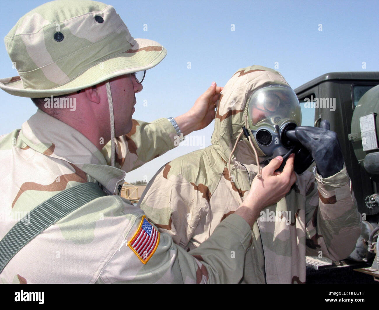 030226-N-1050K-053 Camp Patriot, Kuwait (26. Februar 2003)--Vereinigte Staaten Armee Sgt. Nichols verleiht eine Hand um sicherzustellen, dass ein Seemann hat eine gute Abdichtung auf seine MCU2P Schutzmaske im Rahmen des weiterhin gemeinsame Übungen in Kuwait statt.  Das Òone-TeamÓ-Konzept von US-Soldatinnen und Soldaten zusammen mit ihrem Koalitionspartner praktiziert wurde der Schlüssel zu starken Alliierten Beziehungen bei Camp Patriot.  Nichols ist mit der 567th Cargo Transfer Company, 24. Bataillon von Fort Eustis, Virginia bereitgestellt.  Foto: U.S. Navy Journalist 1. Klasse Joseph Krypel.  (FREIGEGEBEN) US Marine 030226-N-1050K-053 Vereinigte Stockfoto