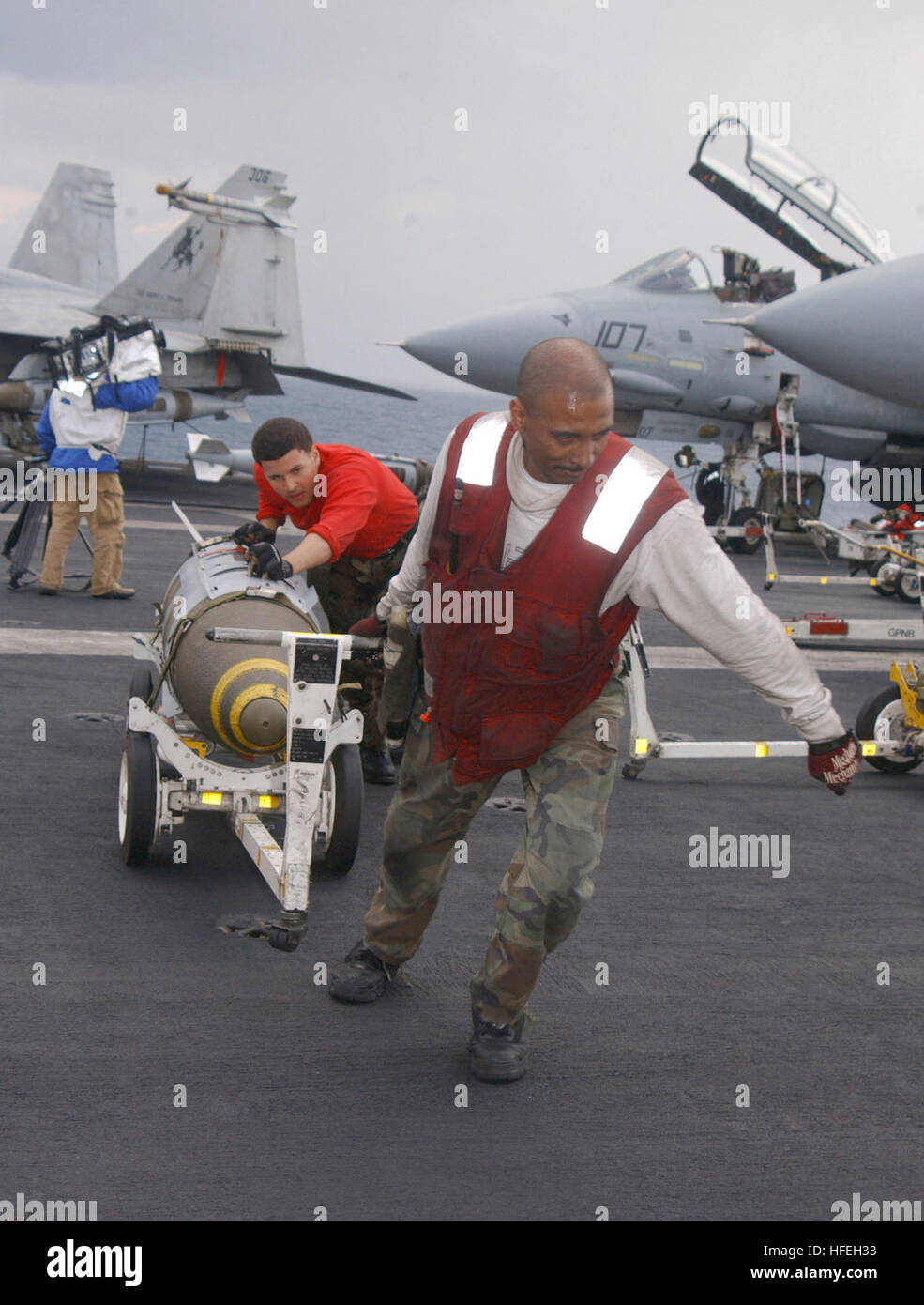 030321-N-0382O-504 das Mittelmeer (21. März 2003)--Aviation Ordnancemen zugeordnet "The Schwertkämpfer" der Kämpfer-Geschwader dreißig zwei (VF-32) übertragen 2.000 lb gemeinsame gerichtete Angriff Munition (JDAMs) zum Hochladen auf eine F-14 b Tomcat-Jagdflugzeug.  JDAMs gibt Anleitung-Kits, die bestehenden ungelenkte Bomben präzisionsgelenkte Munition der "intelligenten" umzuwandeln. Heckteil enthält ein Inertiales Navigationssystem (INS) und ein global positioning System (GPS). Eine JDAM verbessert die Genauigkeit der ungelenkte Bomben bei jedem Wetter.  Truman ist derzeit im Einsatz und ist die Durchführung von Missionen in s Stockfoto