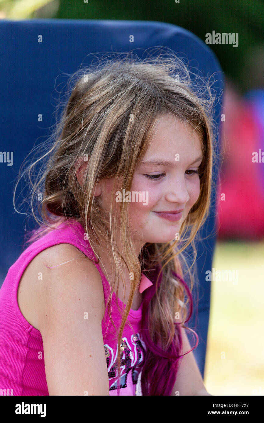 Porträt von einem netten jungen Mädchen über sieben Jahre alt, mit einem süßen, schüchternen Lächeln. Stockfoto