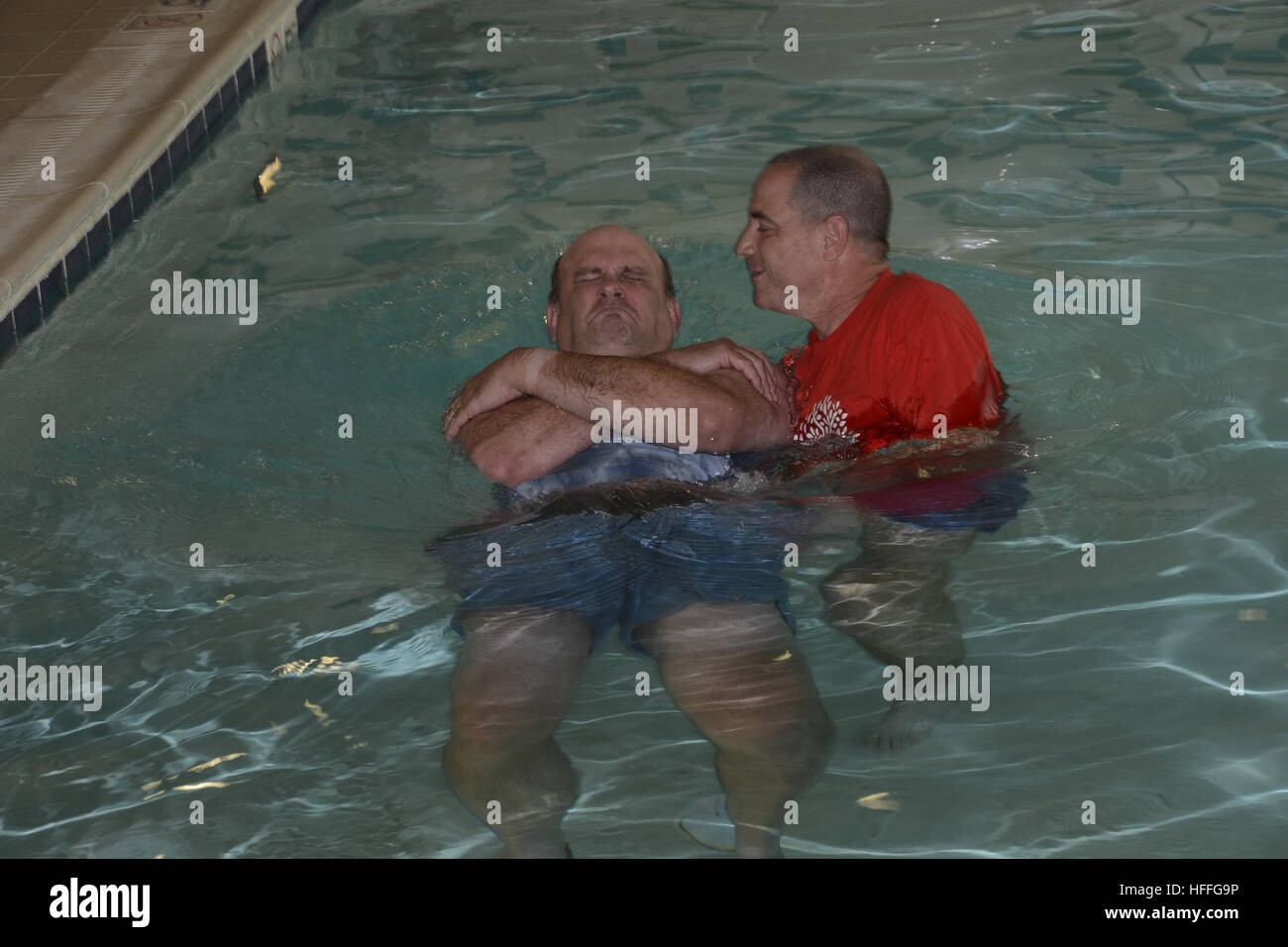Ein Prediger tauft einen Mann während einer Taufzeremonie Stockfoto