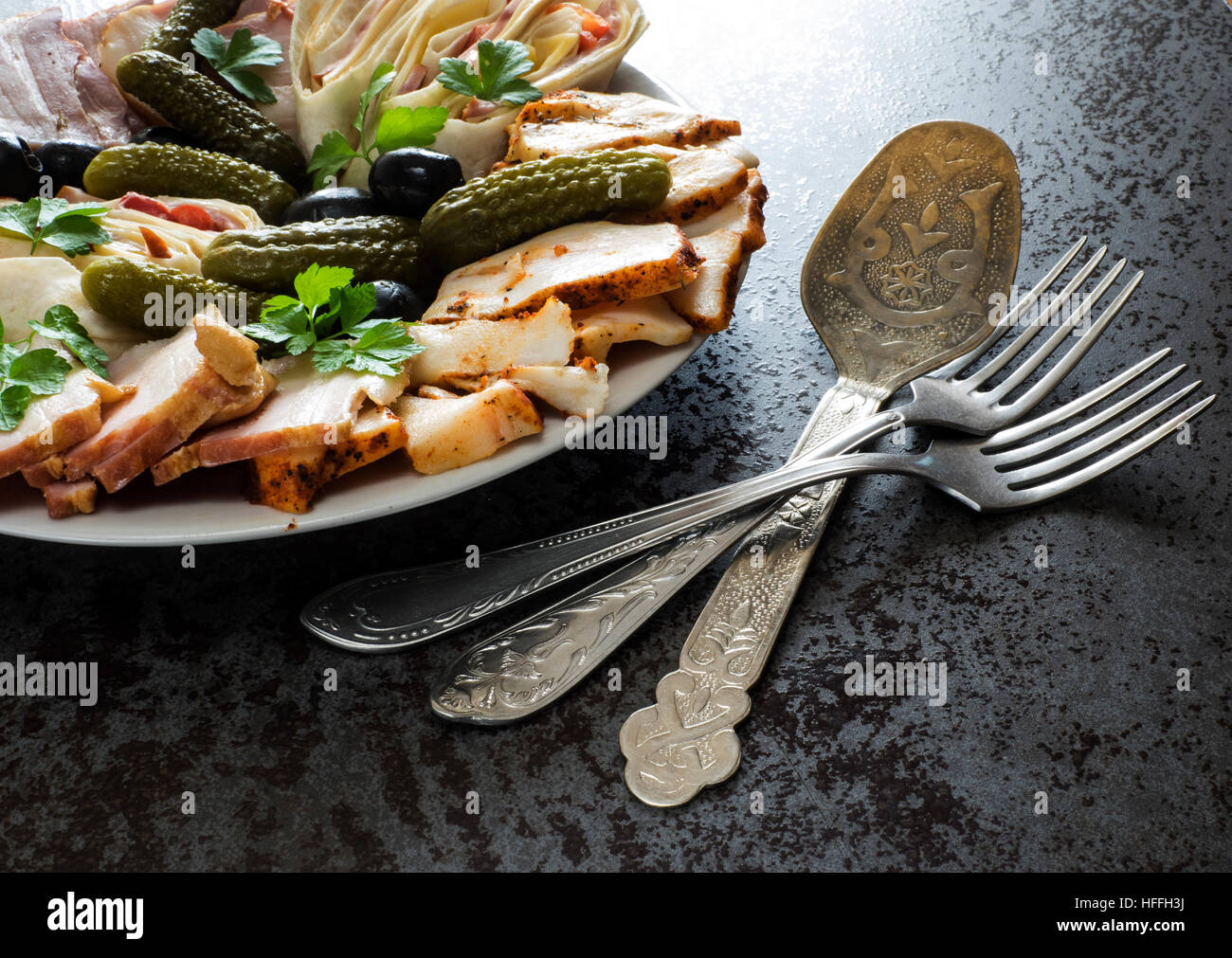 Teller mit Aufschnitt mit Schinken, Speck, Oliven und Gurken Stockfoto