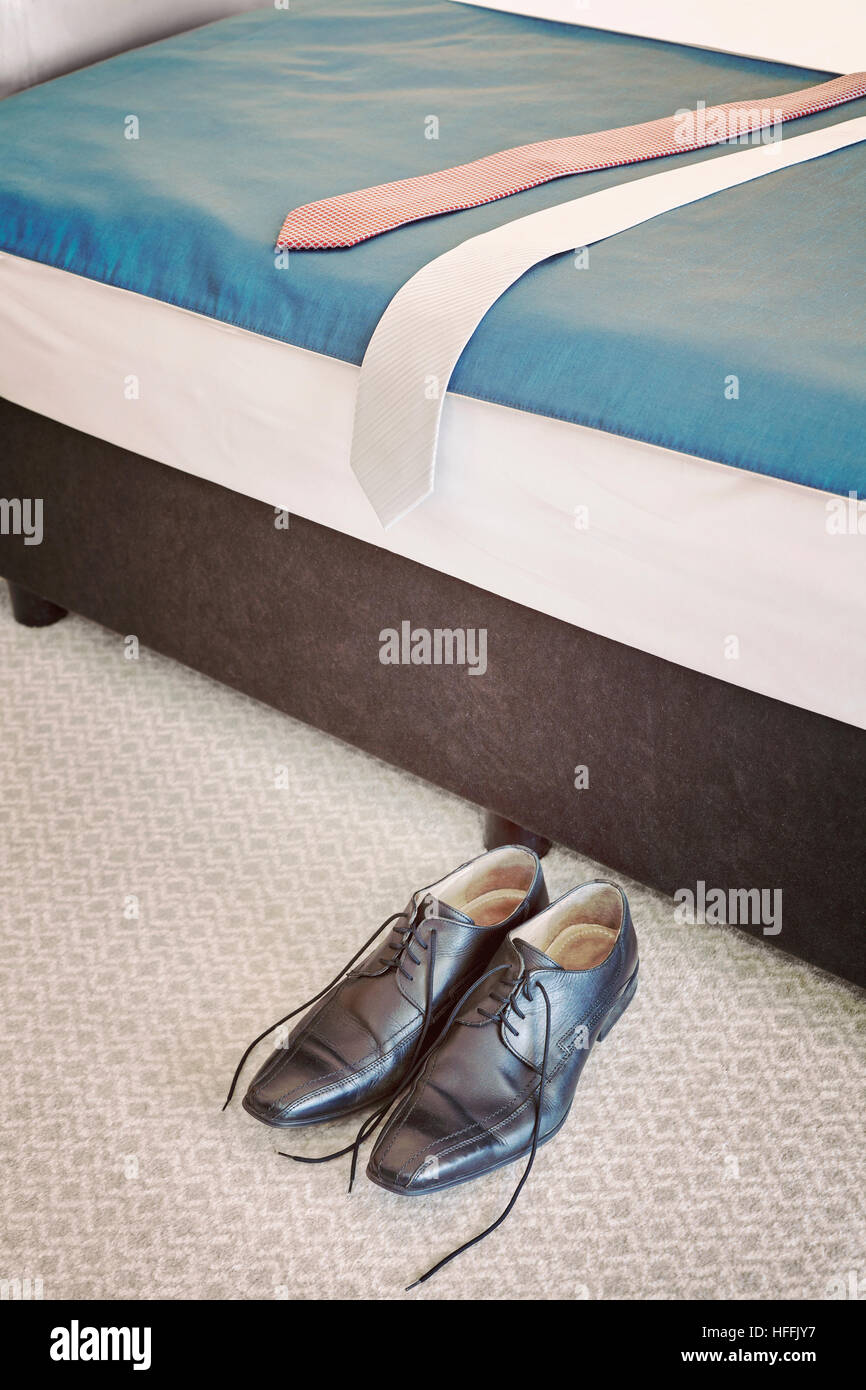Retro getönten schwarzen Lederschuhen und zwei Verbindungen in einem Hotelzimmer. Stockfoto