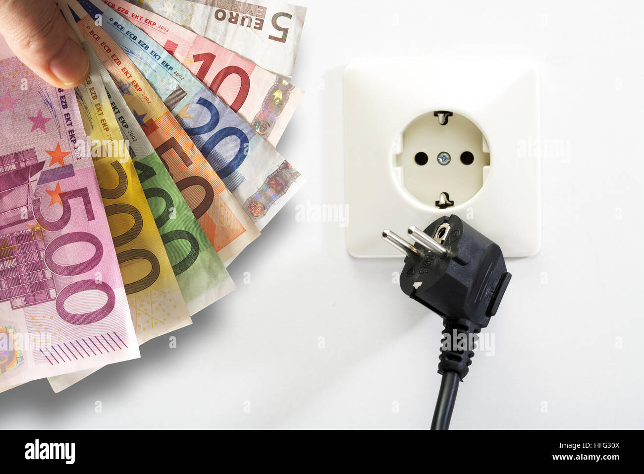 Euro-Scheine, Steckdose und Stecker: steigende Stromkosten Stockfoto