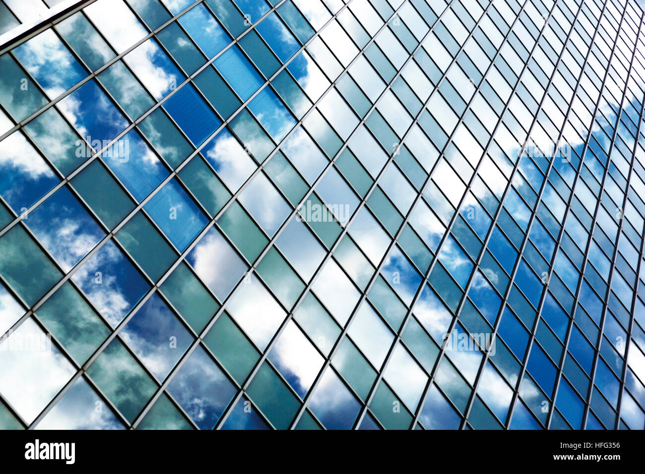 Wolken spiegeln sich in der Glasfassade ein Büroturm Stockfoto